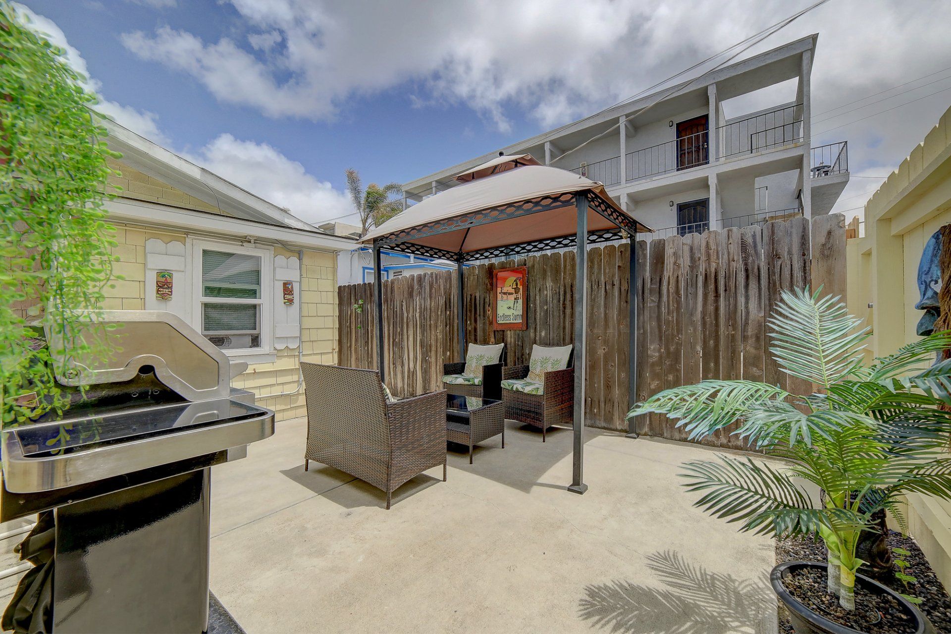a patio with a gazebo and a grill in front of a house .