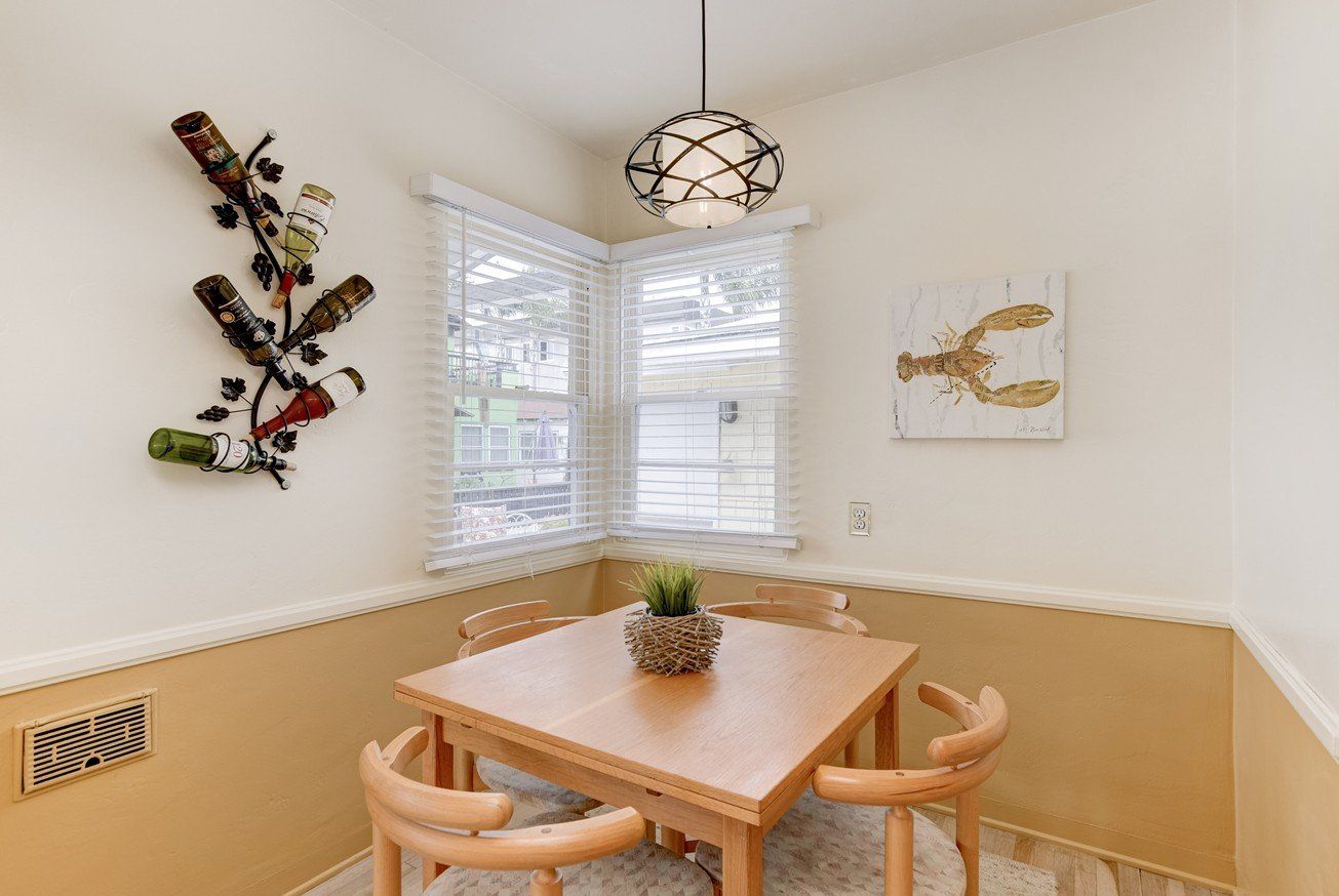 A dining room with a table and chairs and a wine rack on the wall.