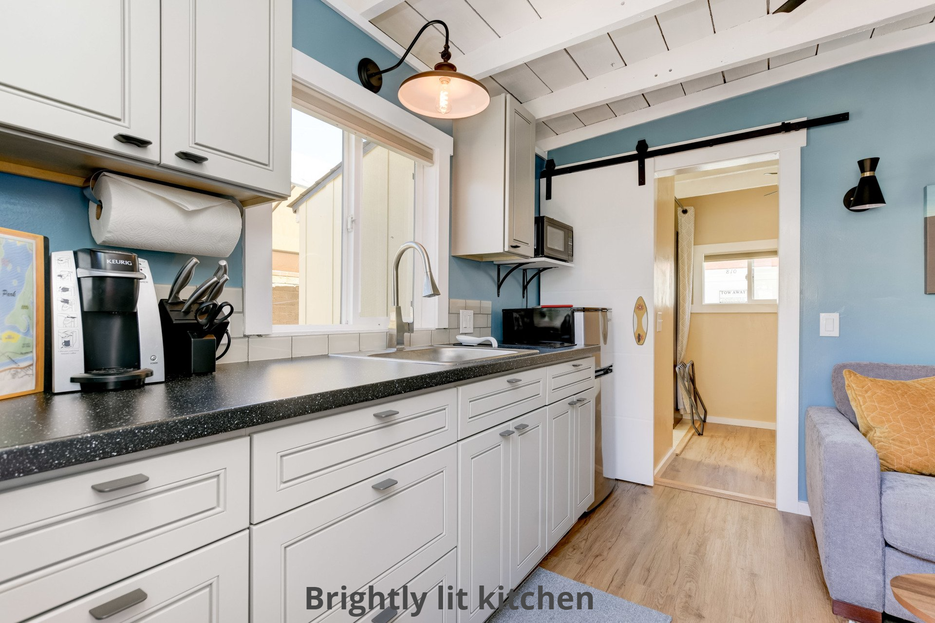 a kitchen with white cabinets and a sliding barn door