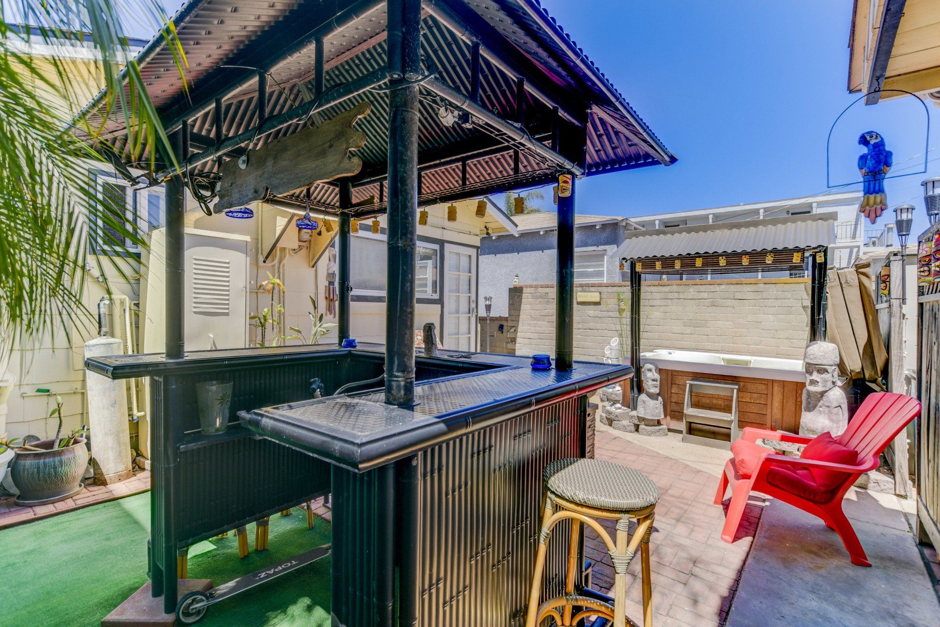 a backyard with a bar , chairs and a hot tub .