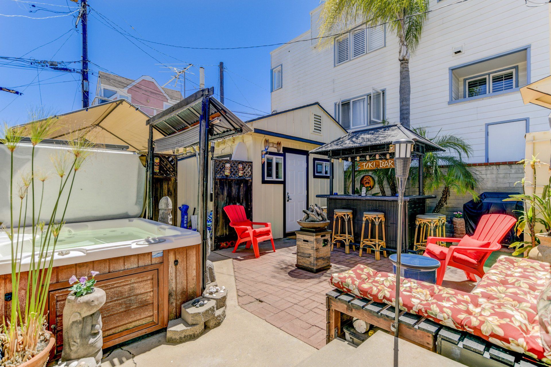 a backyard with a hot tub , chairs , umbrellas and a gazebo .