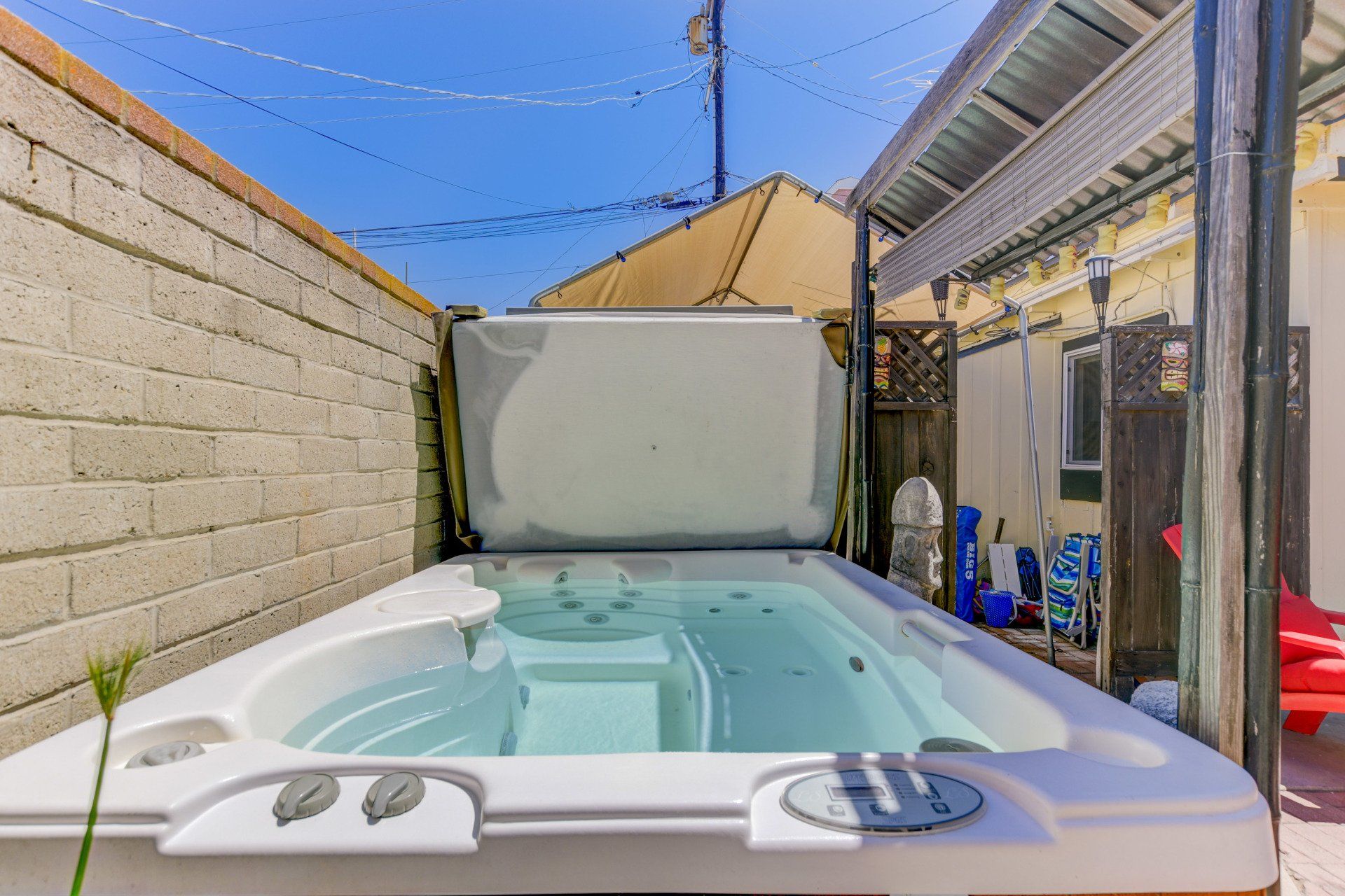 a white hot tub is sitting in the backyard of a house .