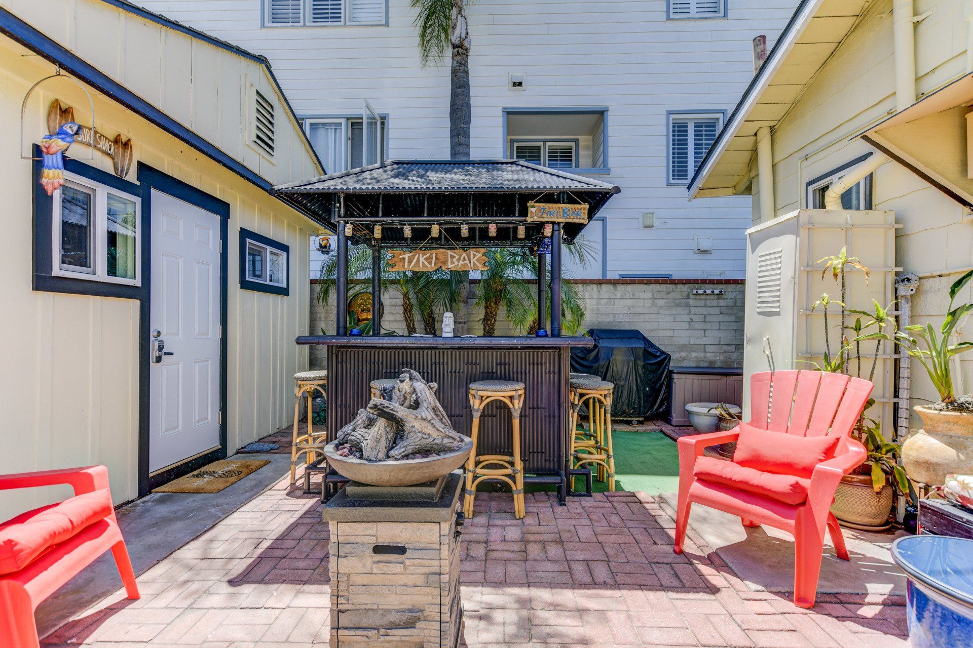 a backyard with a bar , chairs , and a fire pit .