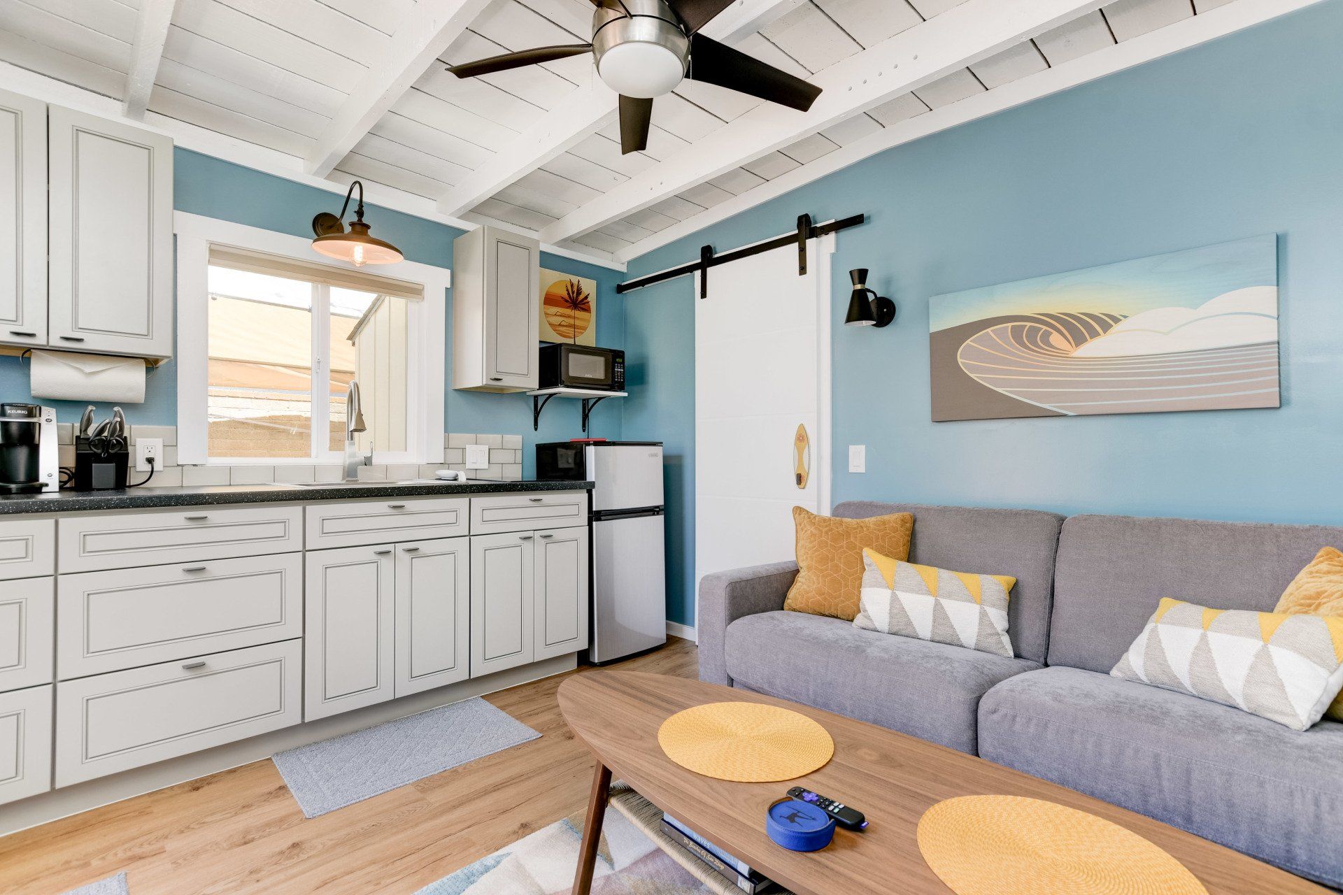 a living room with a couch , table , and ceiling fan .