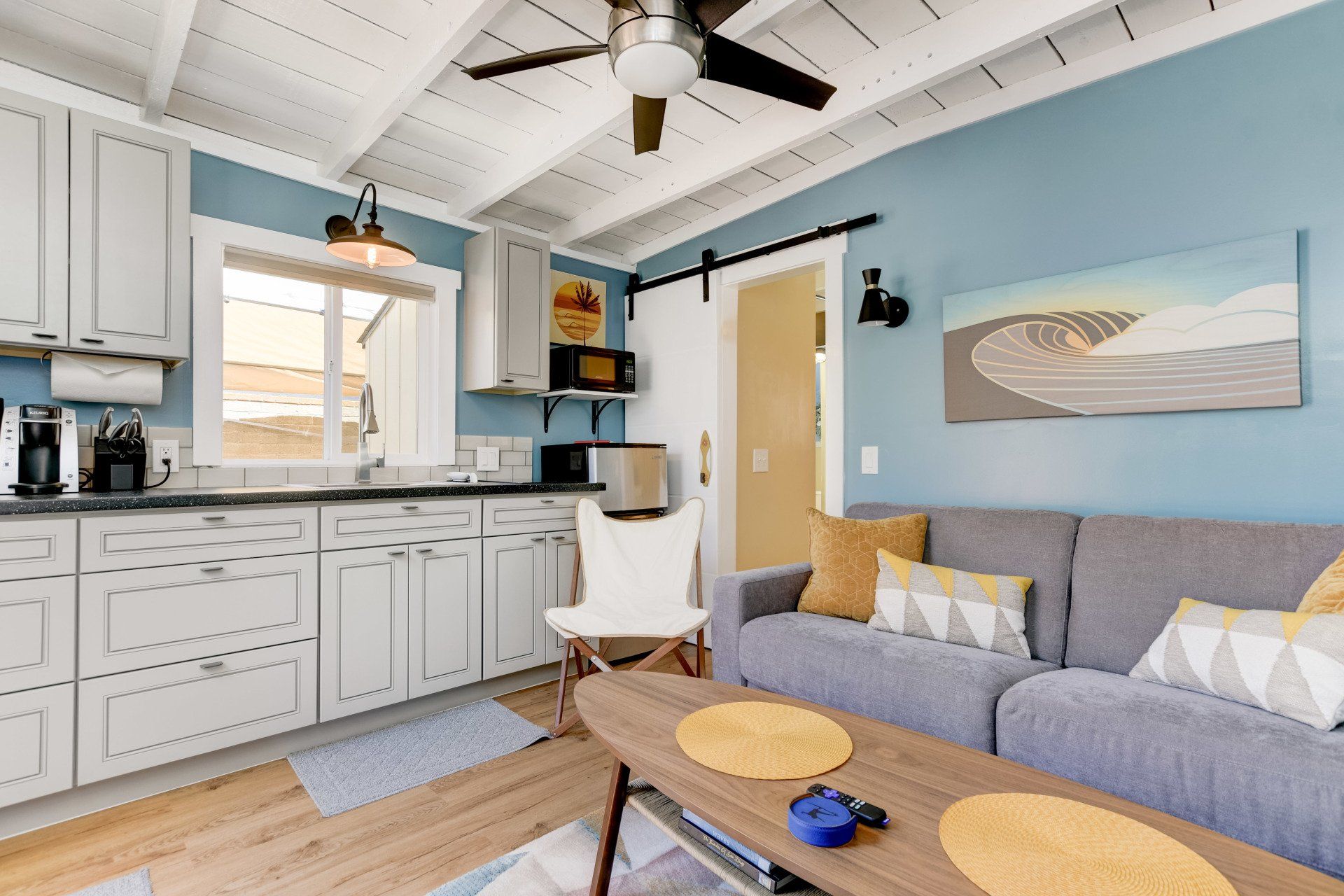 a living room with a couch , table , chair and ceiling fan .