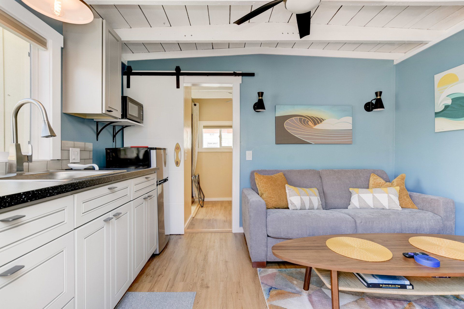 a living room with a couch , coffee table , and kitchen .