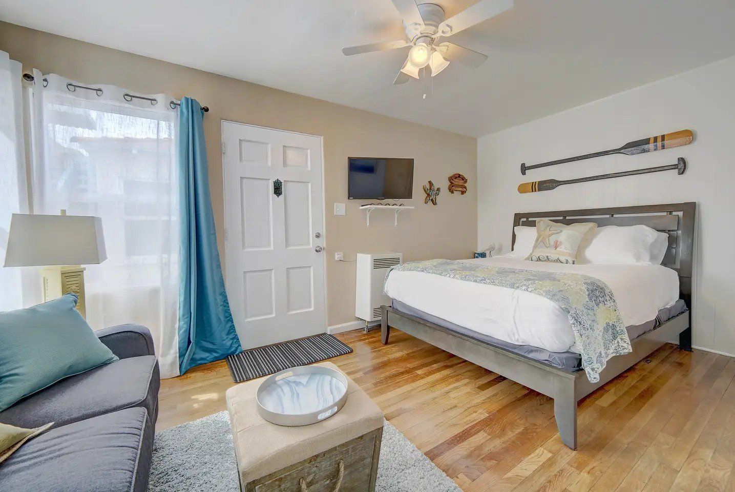 A bedroom with a bed , couch , coffee table and television.