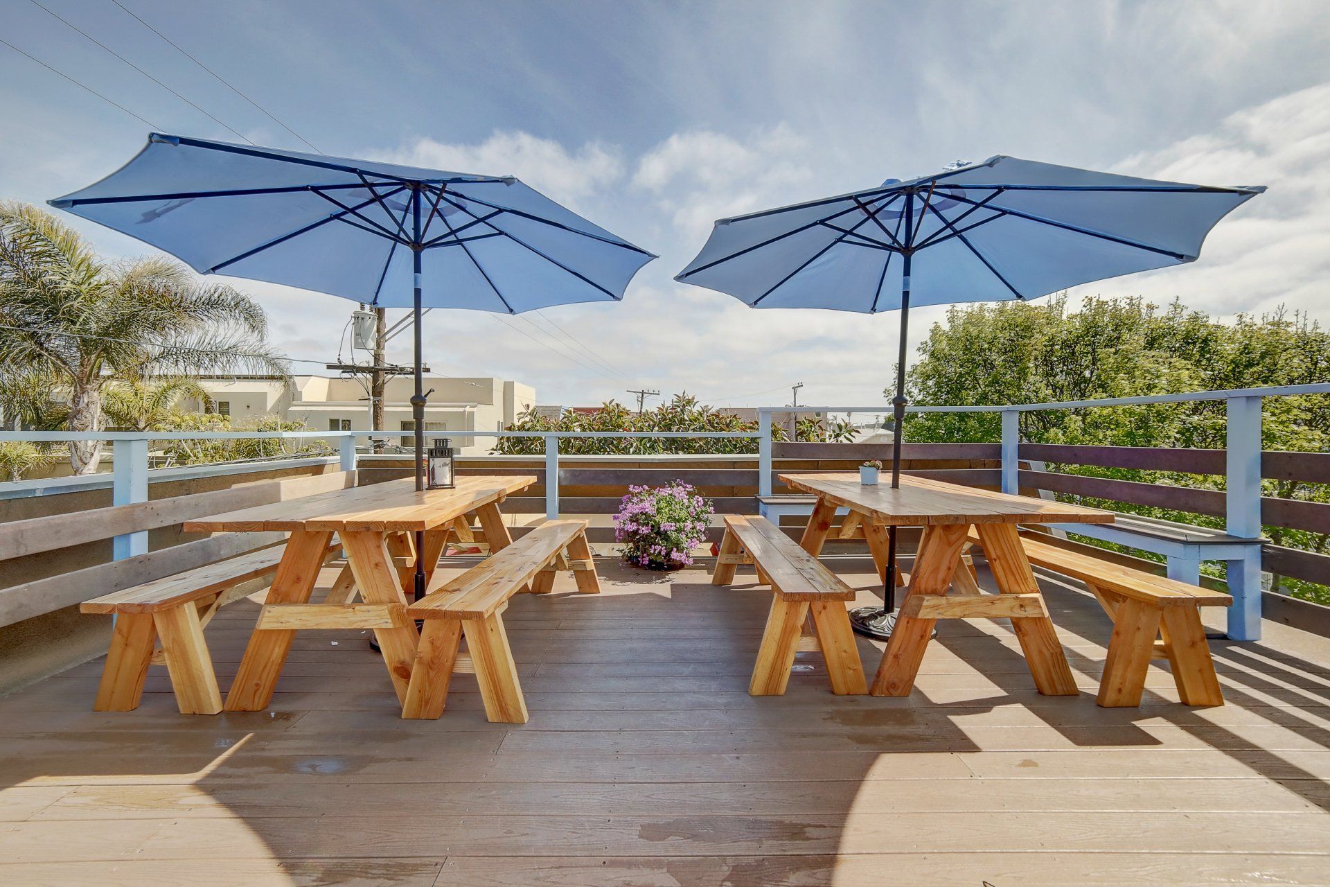 a wooden deck with picnic tables and umbrellas on it