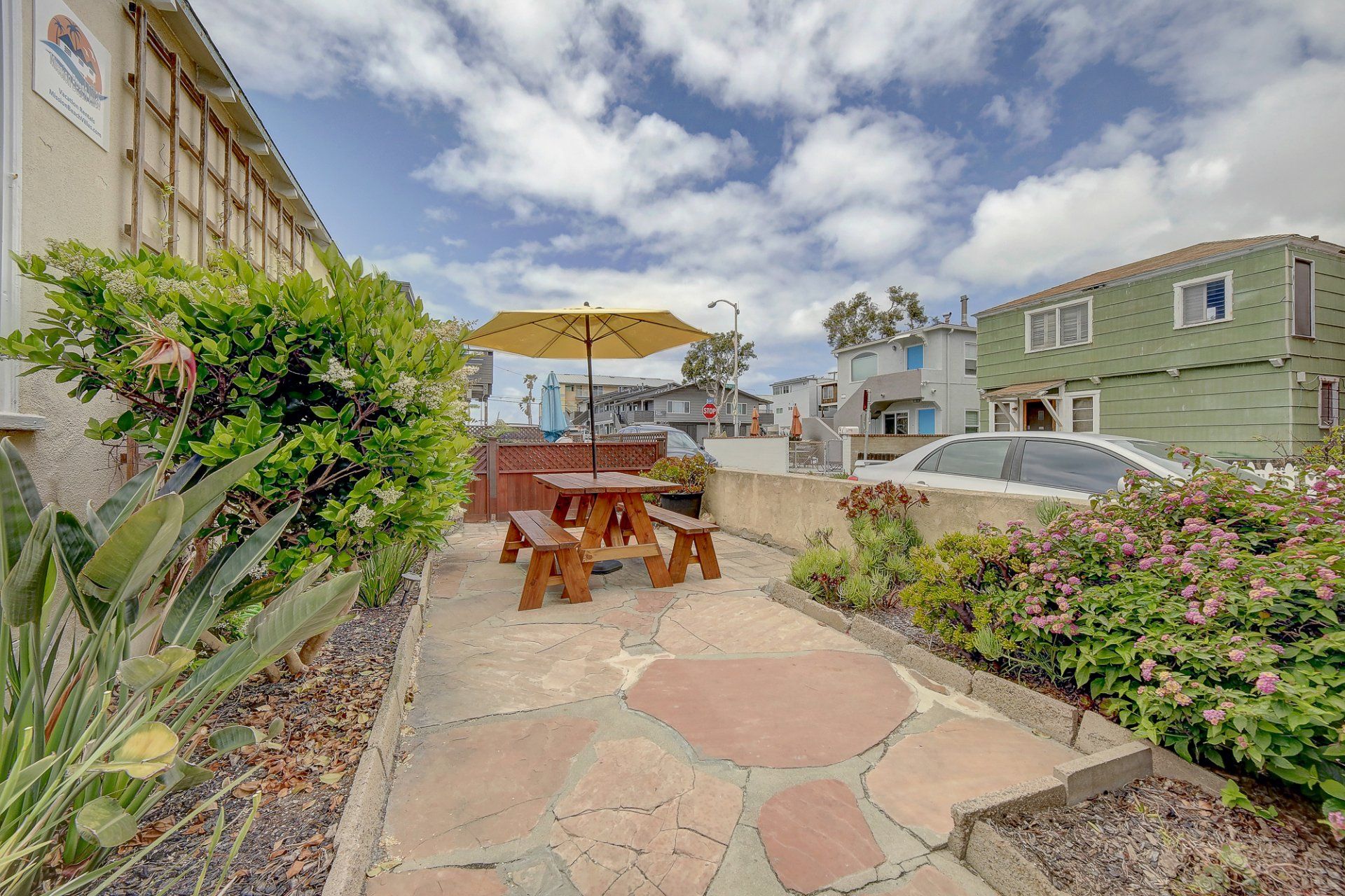 There is a picnic table with an umbrella in the backyard.