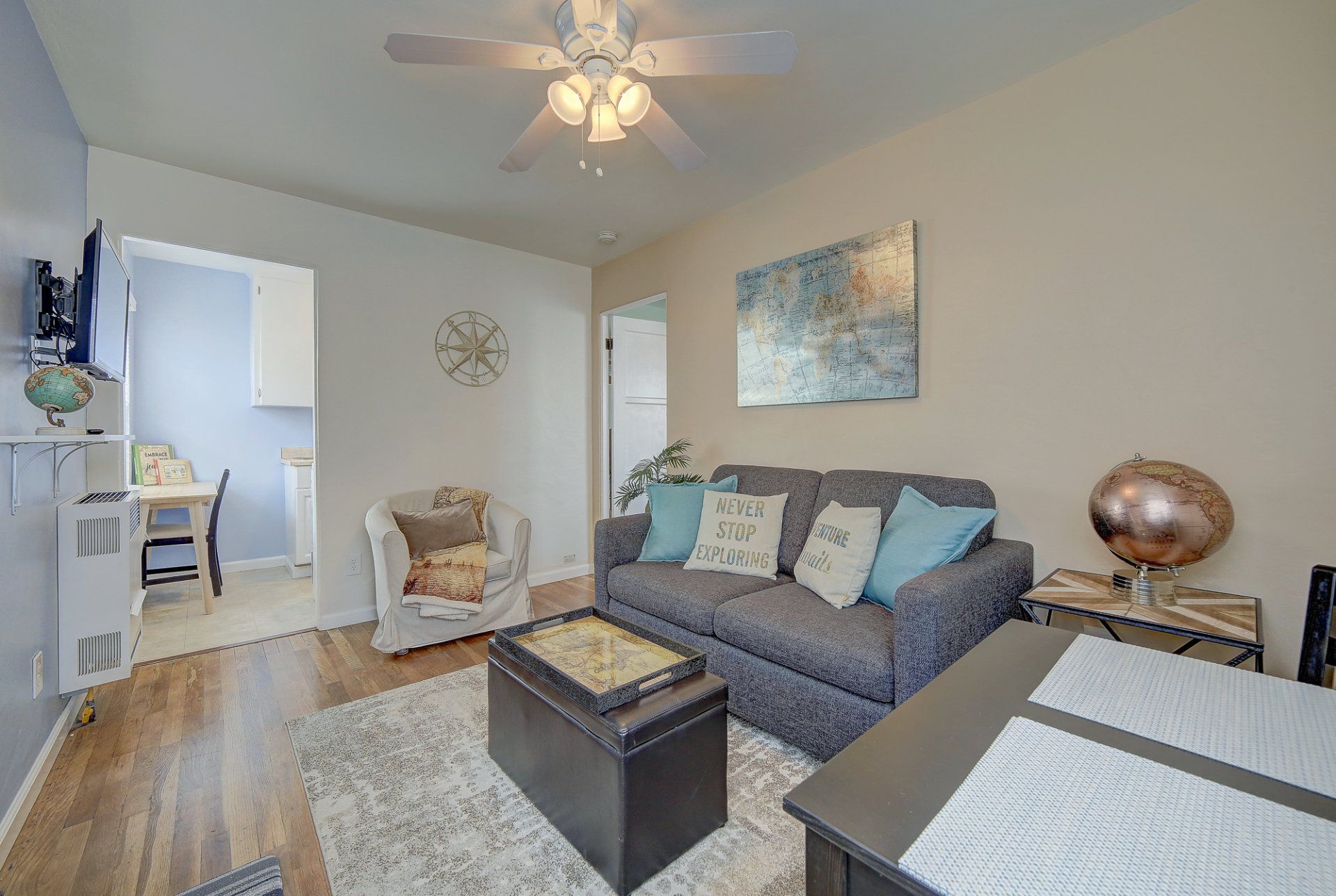 a living room with a couch , table , chair and ceiling fan .