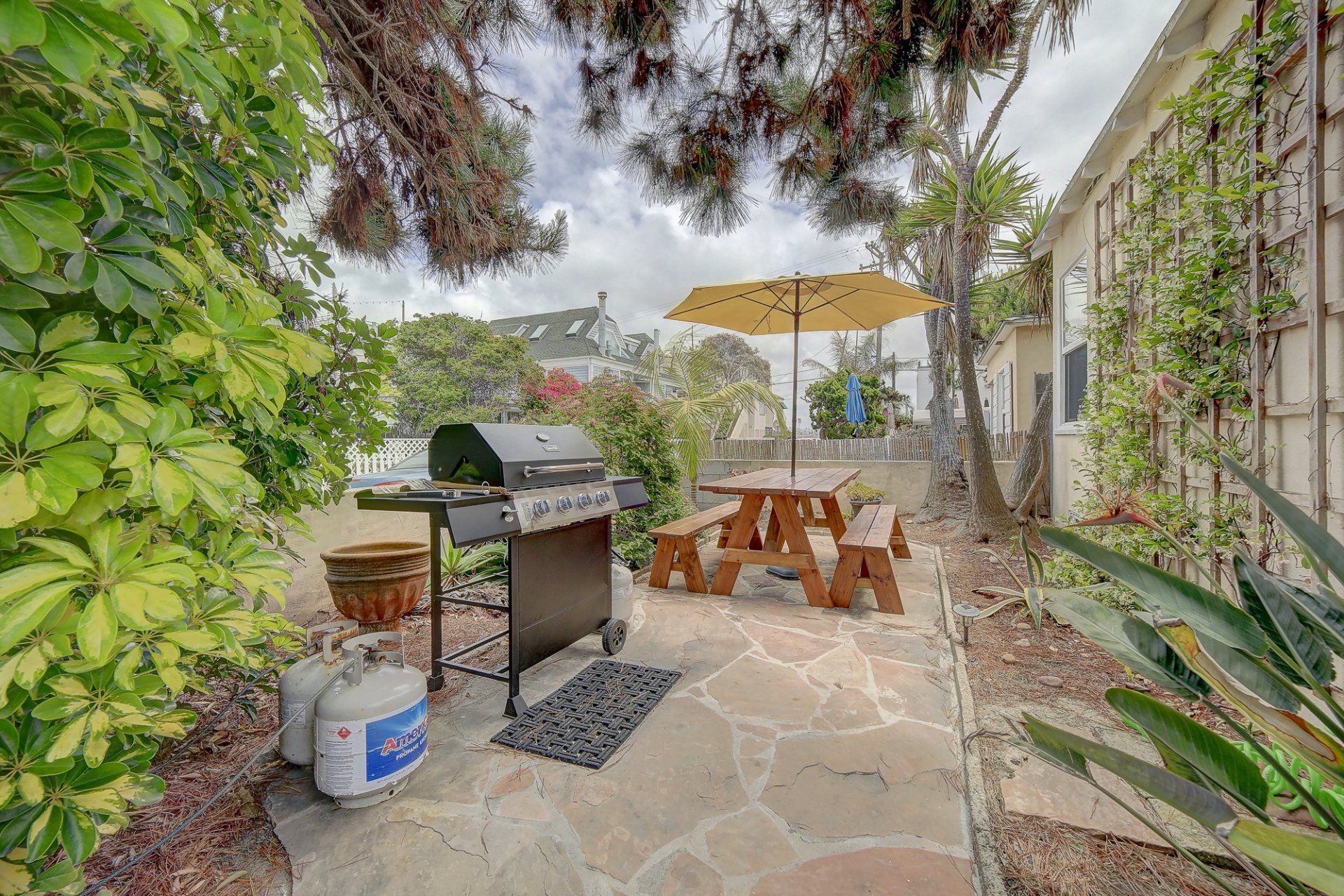 There is a grill and a picnic table in the backyard.