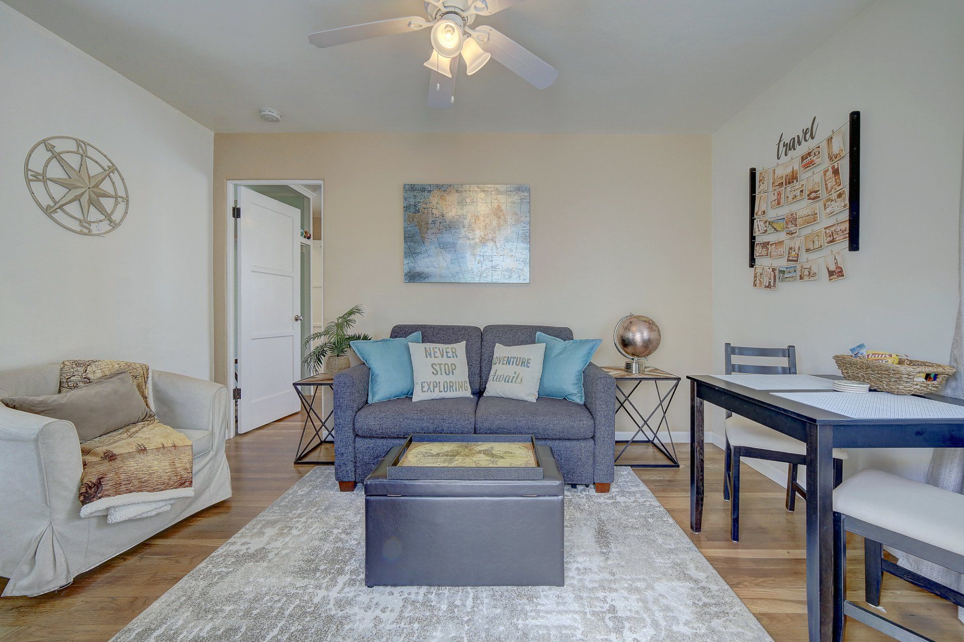 a living room with a couch , table , chairs and a ceiling fan .