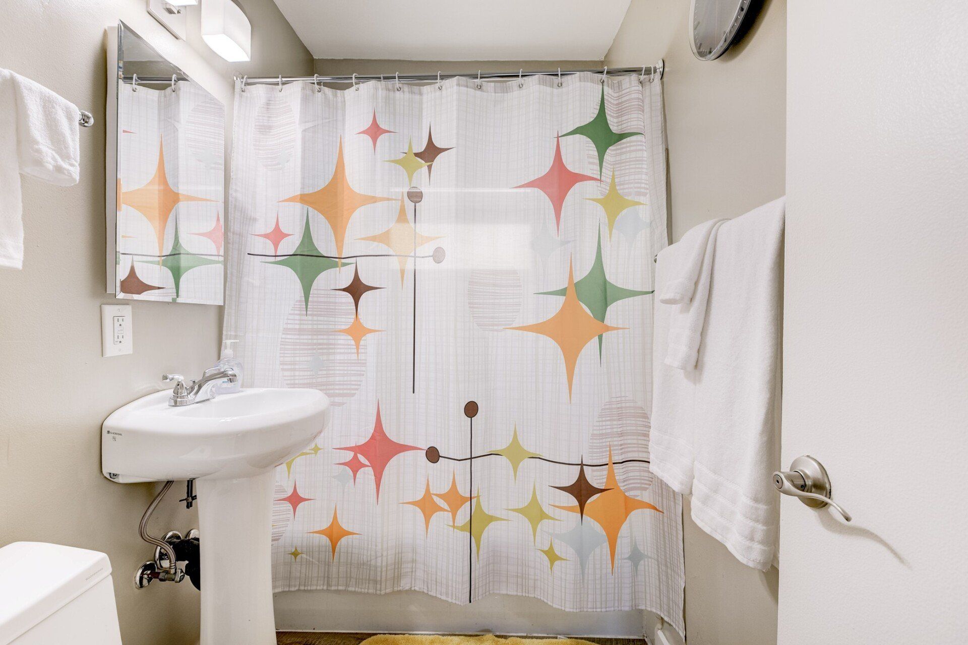 A bathroom with a shower curtain and a sink