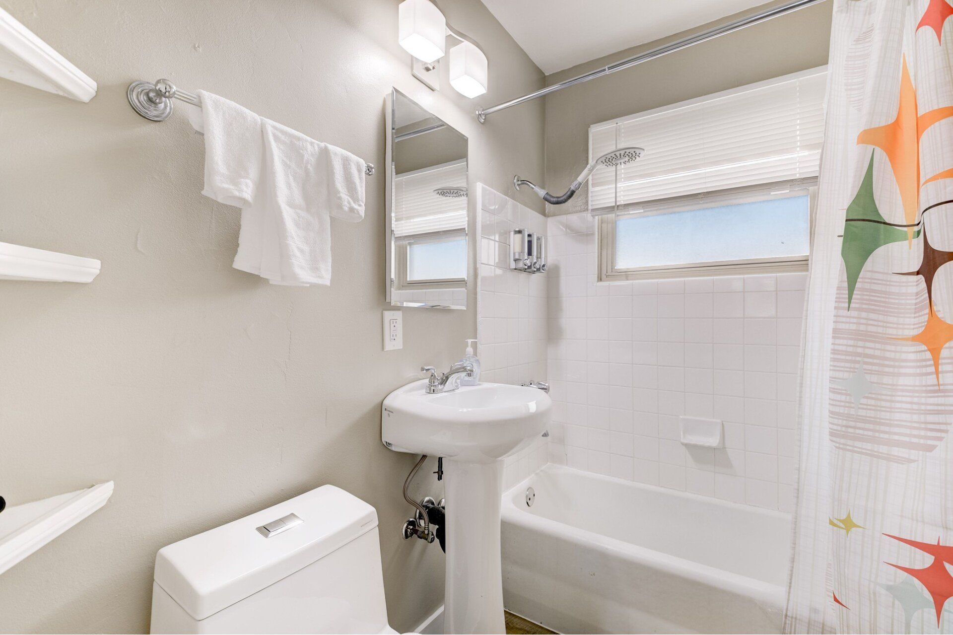 A bathroom with a toilet , sink , and bathtub.