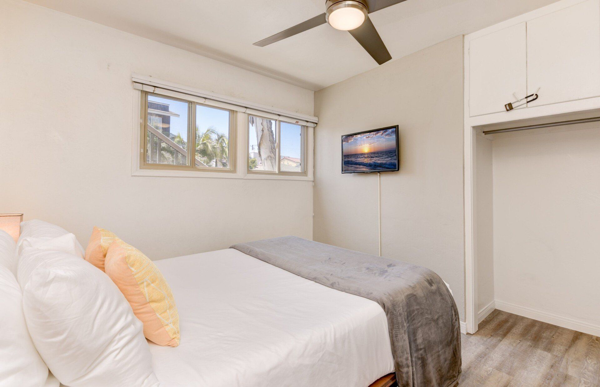 a bedroom with a bed , ceiling fan , and television .