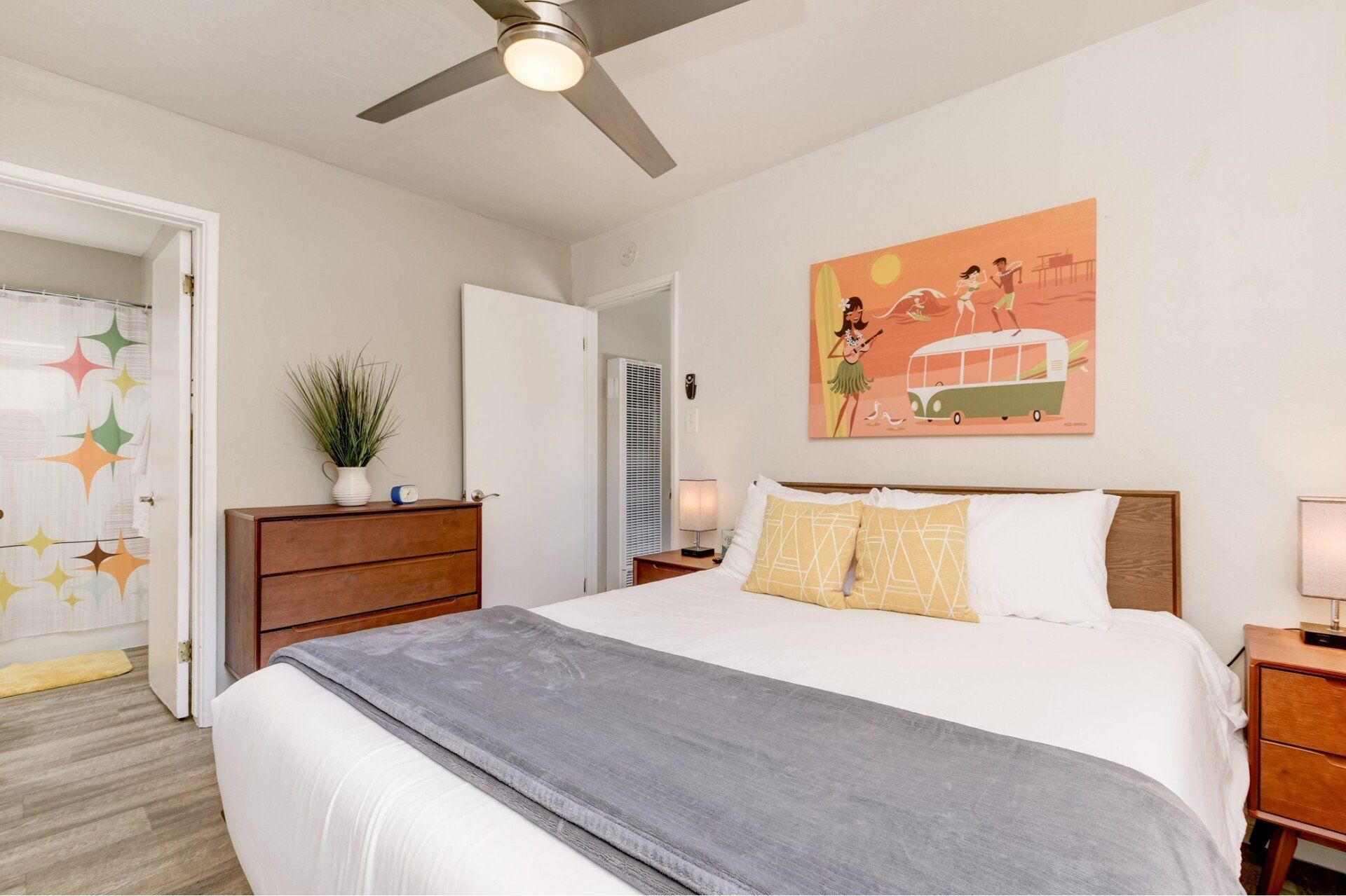 a bedroom with a king size bed , nightstand , dresser and ceiling fan .