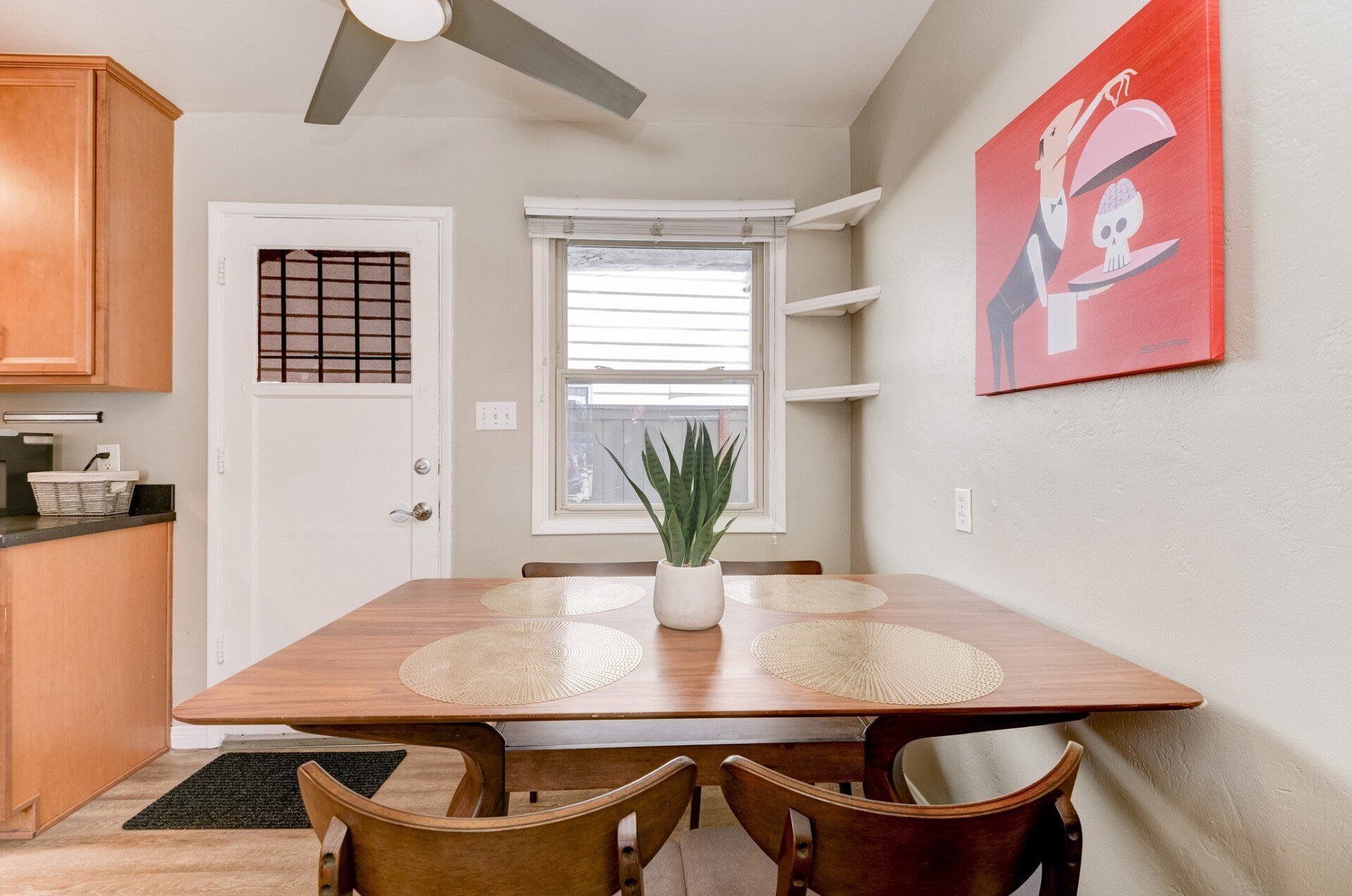 a dining room with a table and chairs and a painting on the wall .