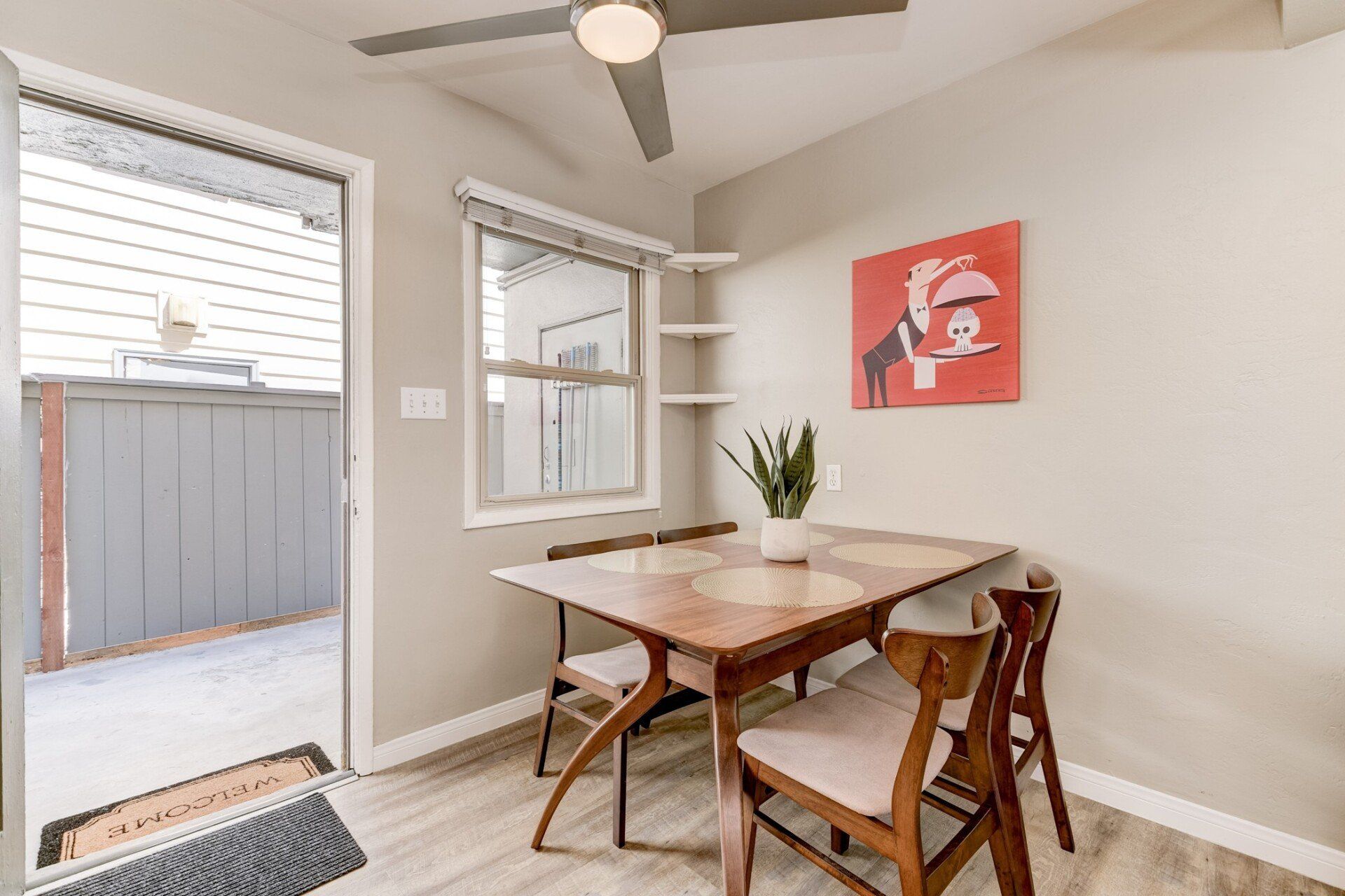 a dining room with a table and chairs and a ceiling fan .