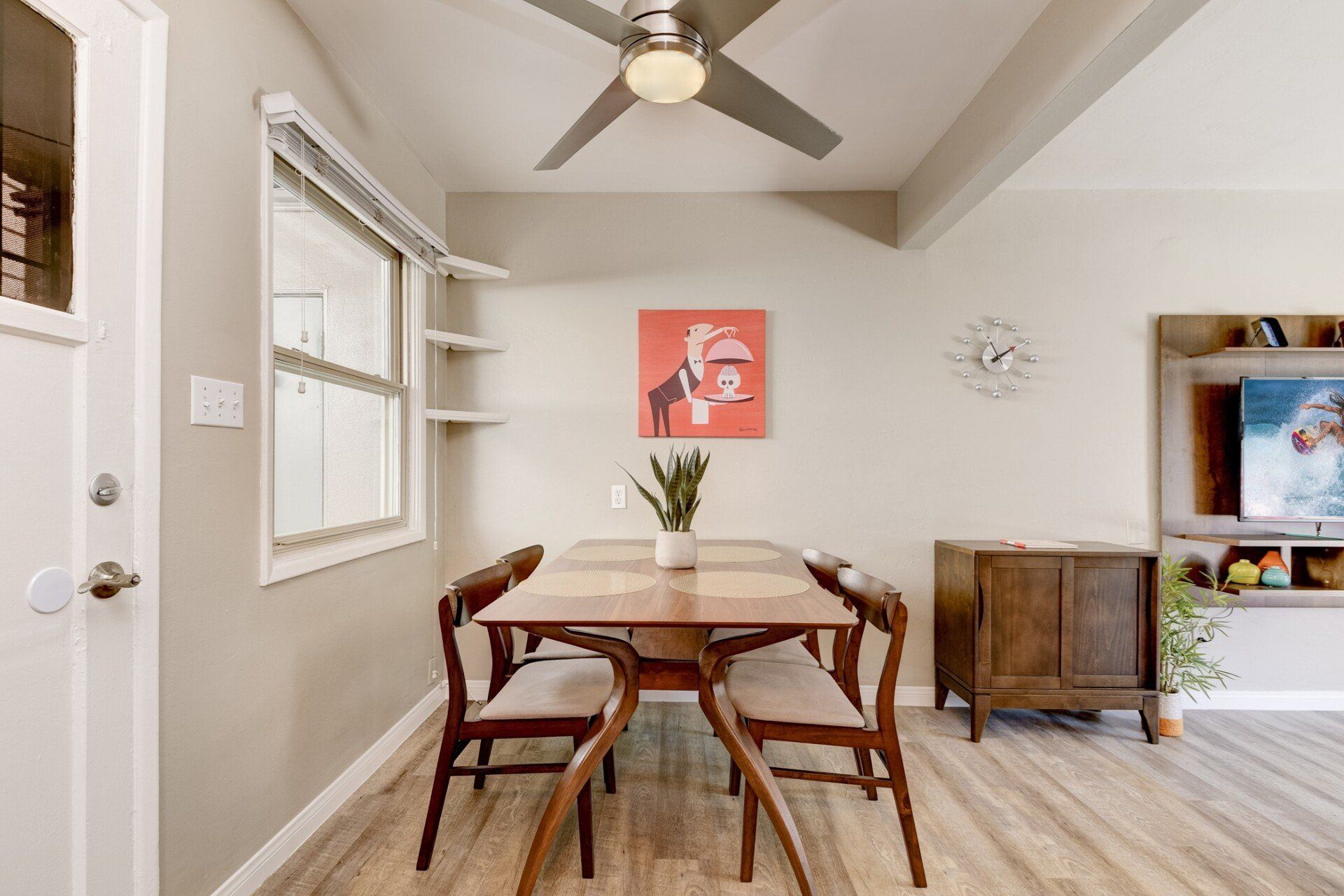 a dining room with a table and chairs and a ceiling fan .