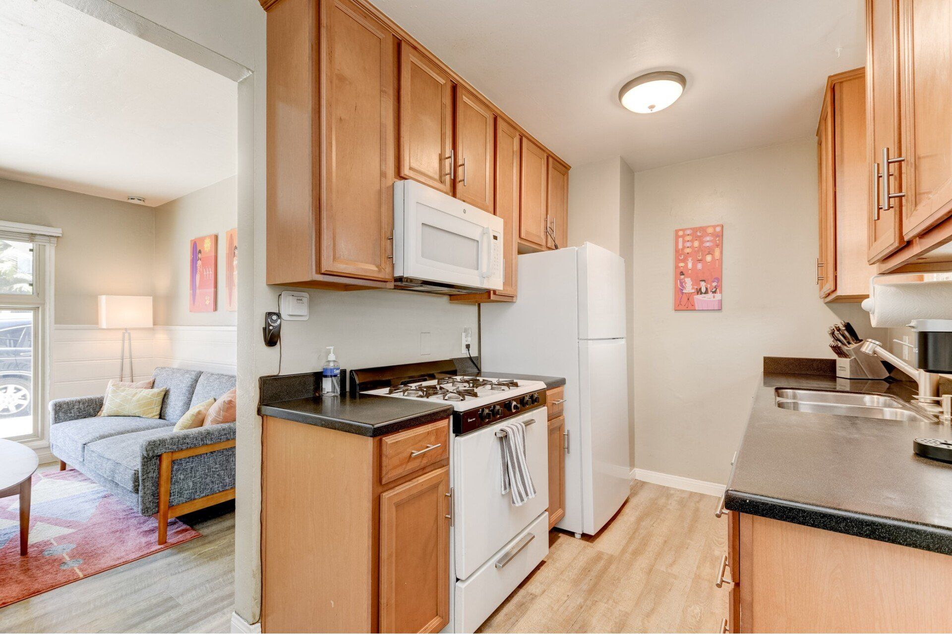 a kitchen with a stove , refrigerator , microwave and sink .