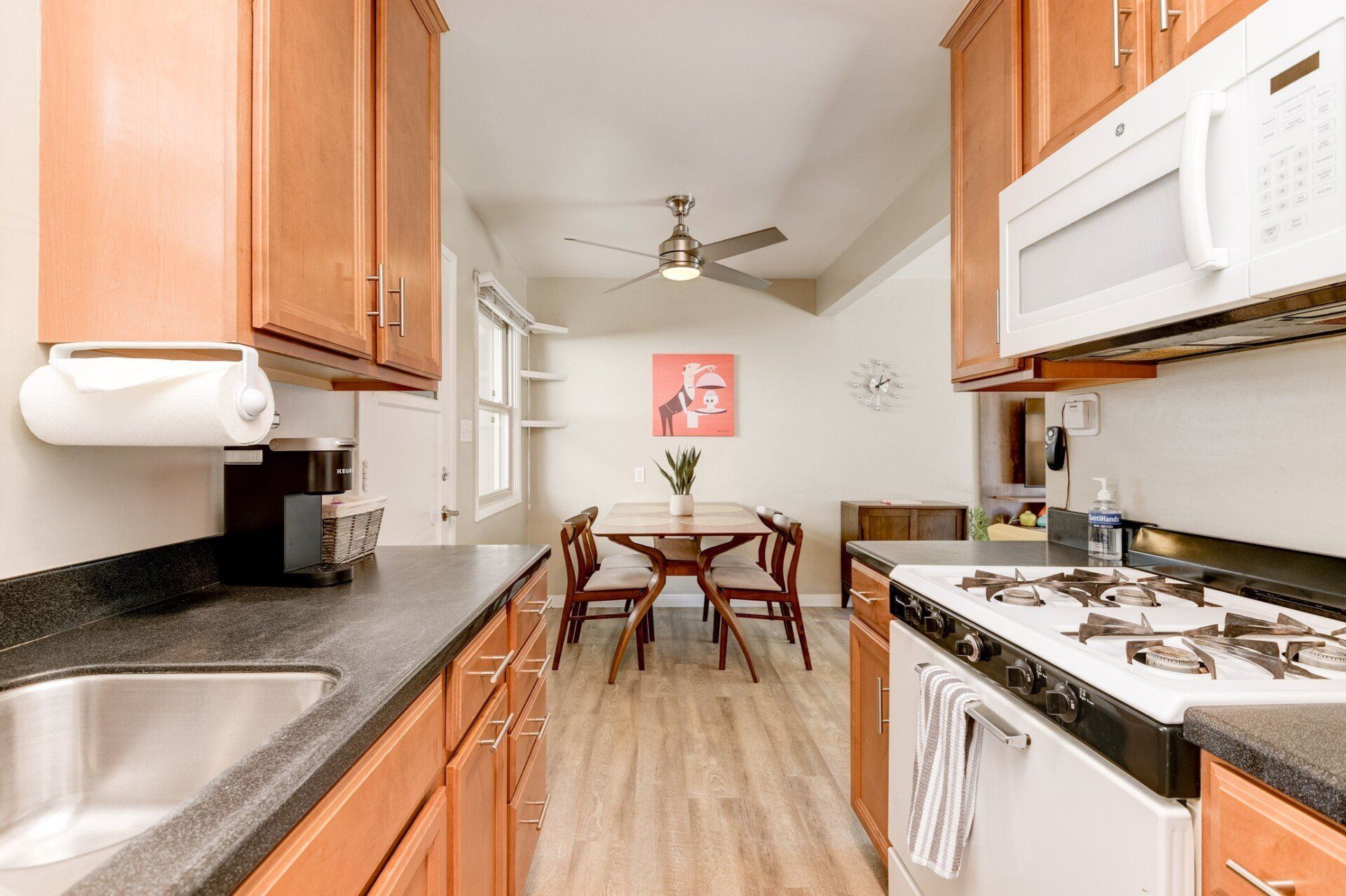 a kitchen with wooden cabinets , a stove , a sink , and a microwave .