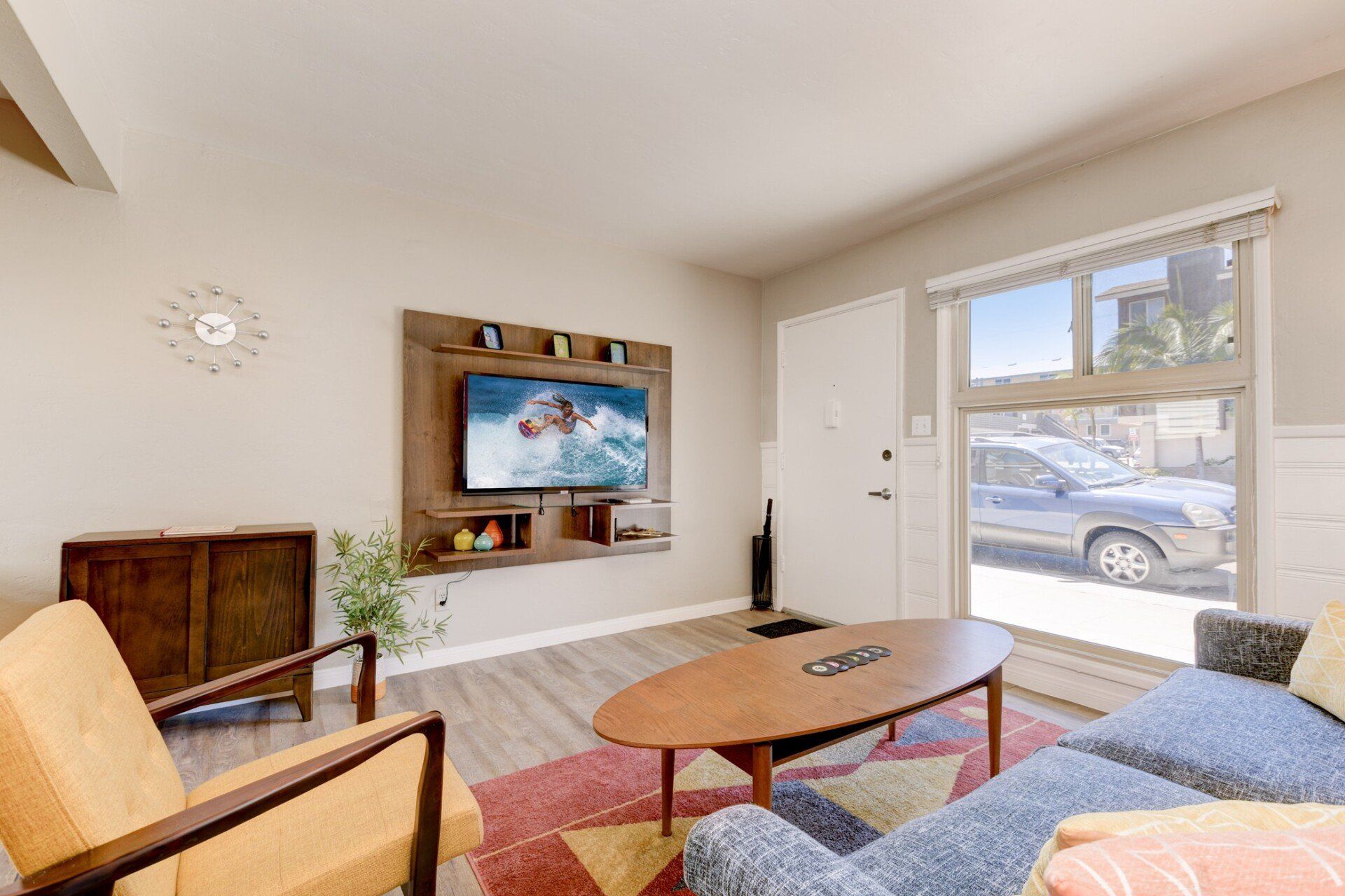 a living room with a couch , chair , coffee table and television .