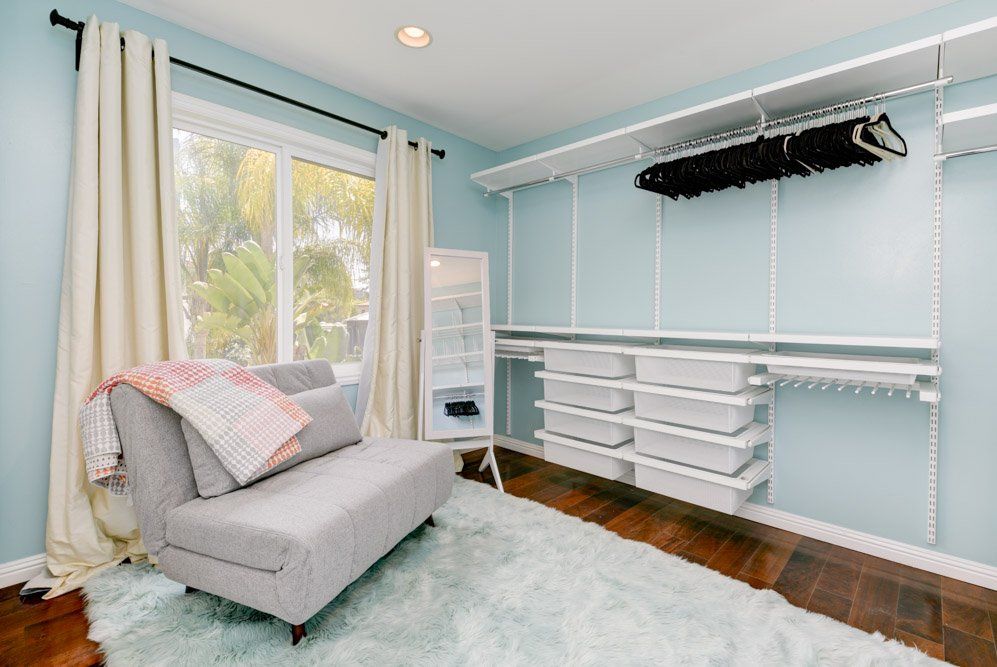 a walk in closet with a couch and a window .