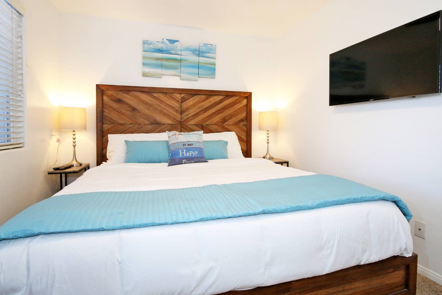 A bedroom with a king size bed and a flat screen tv.