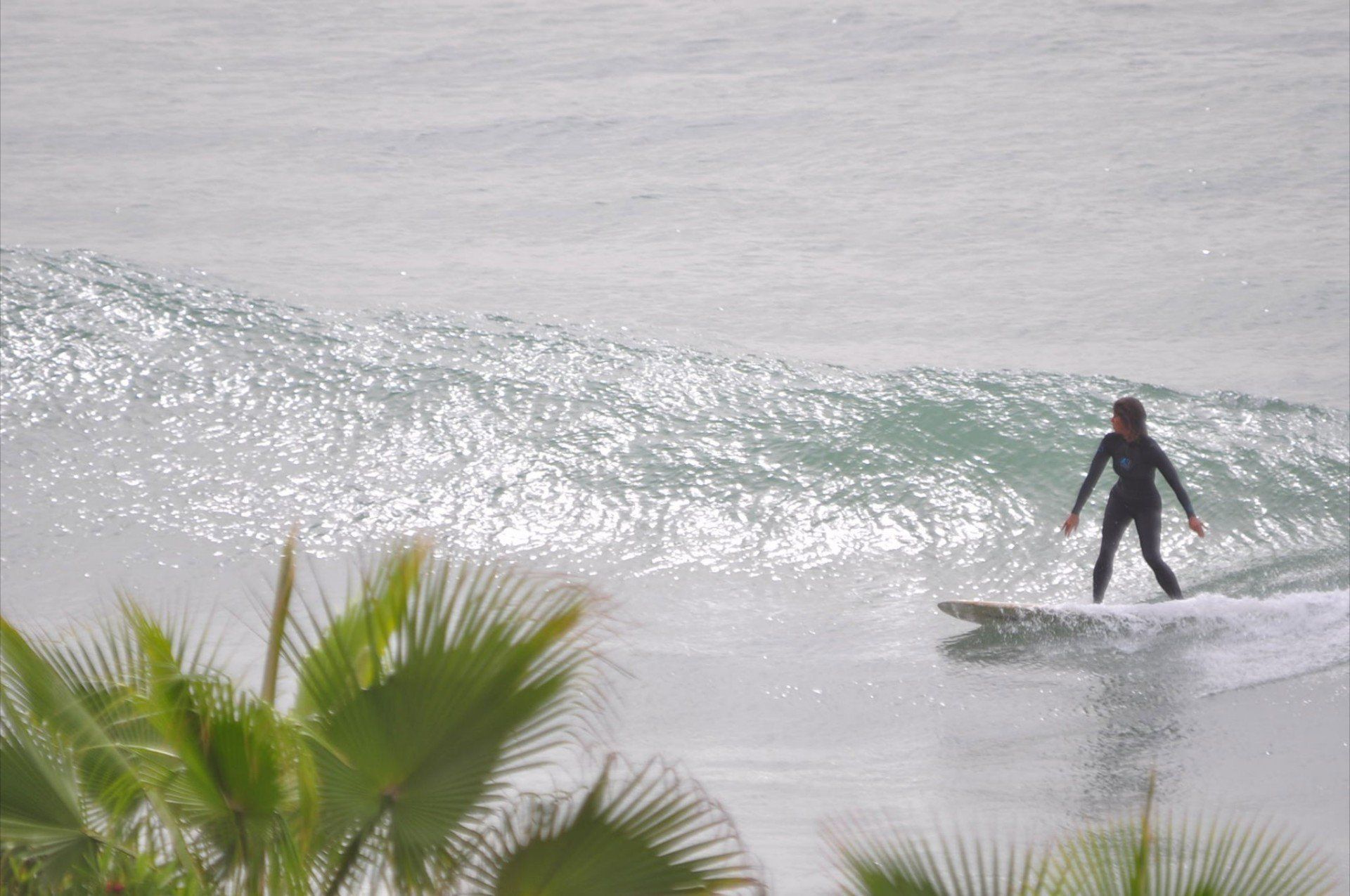 a person is riding a wave on a surfboard in the ocean .