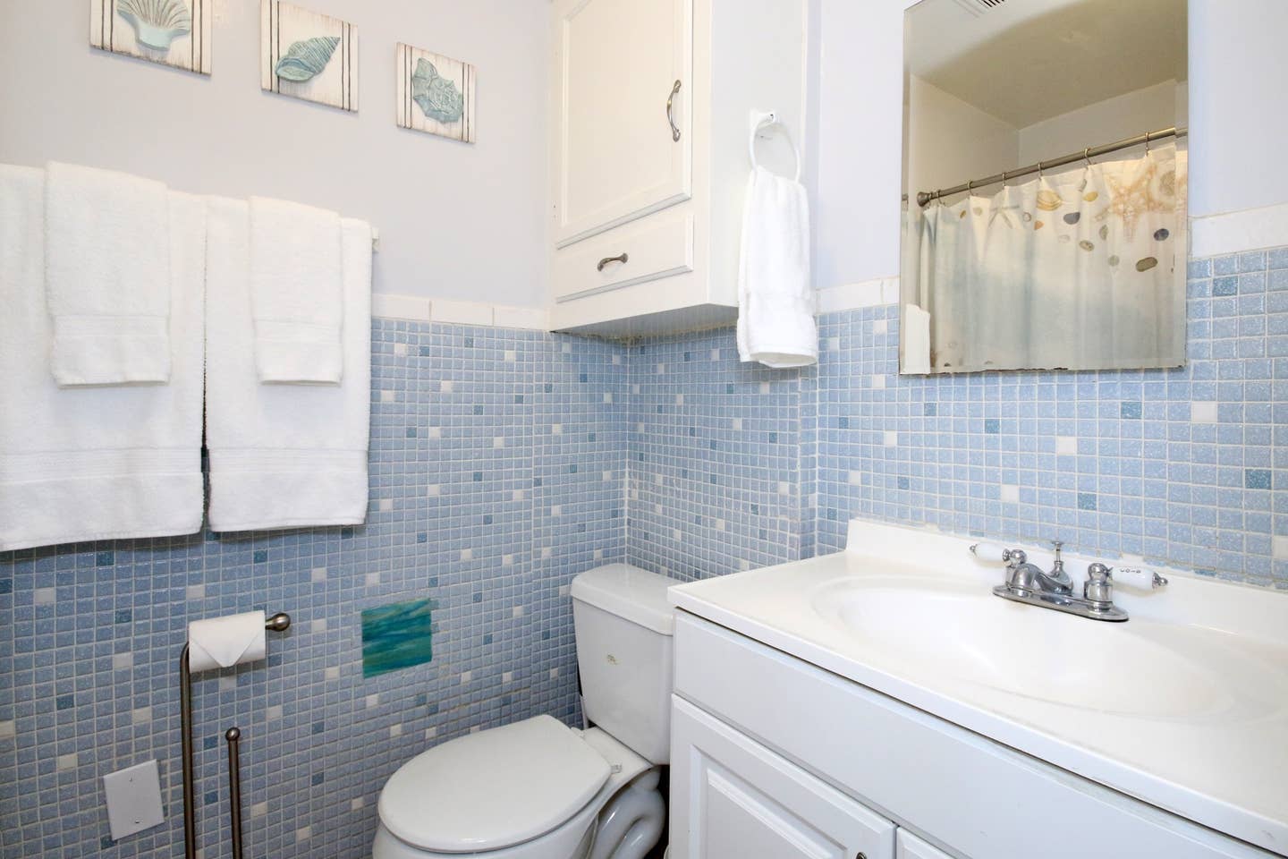 a bathroom with a toilet , sink and mirror