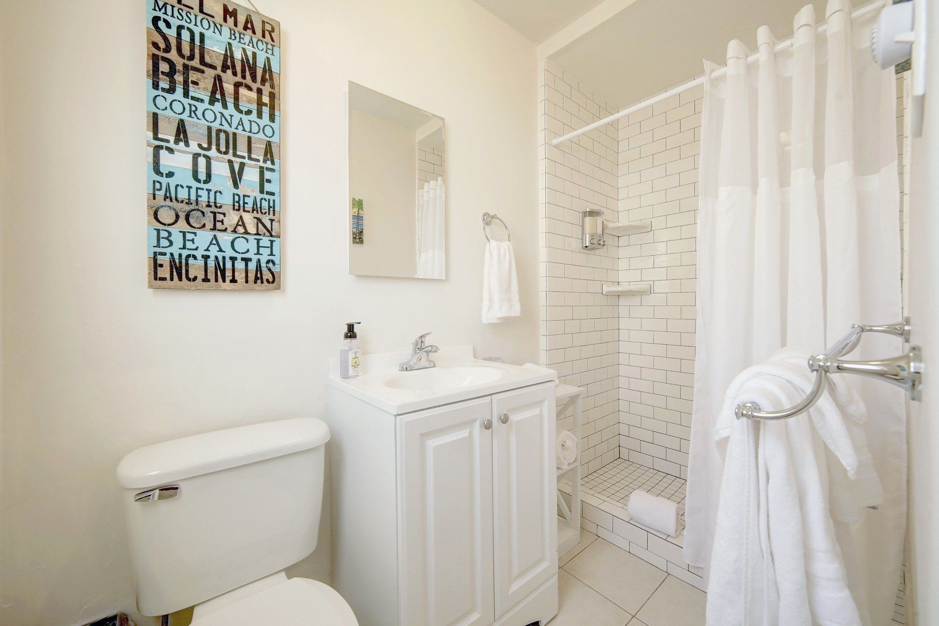 A bathroom with a toilet , sink and shower.