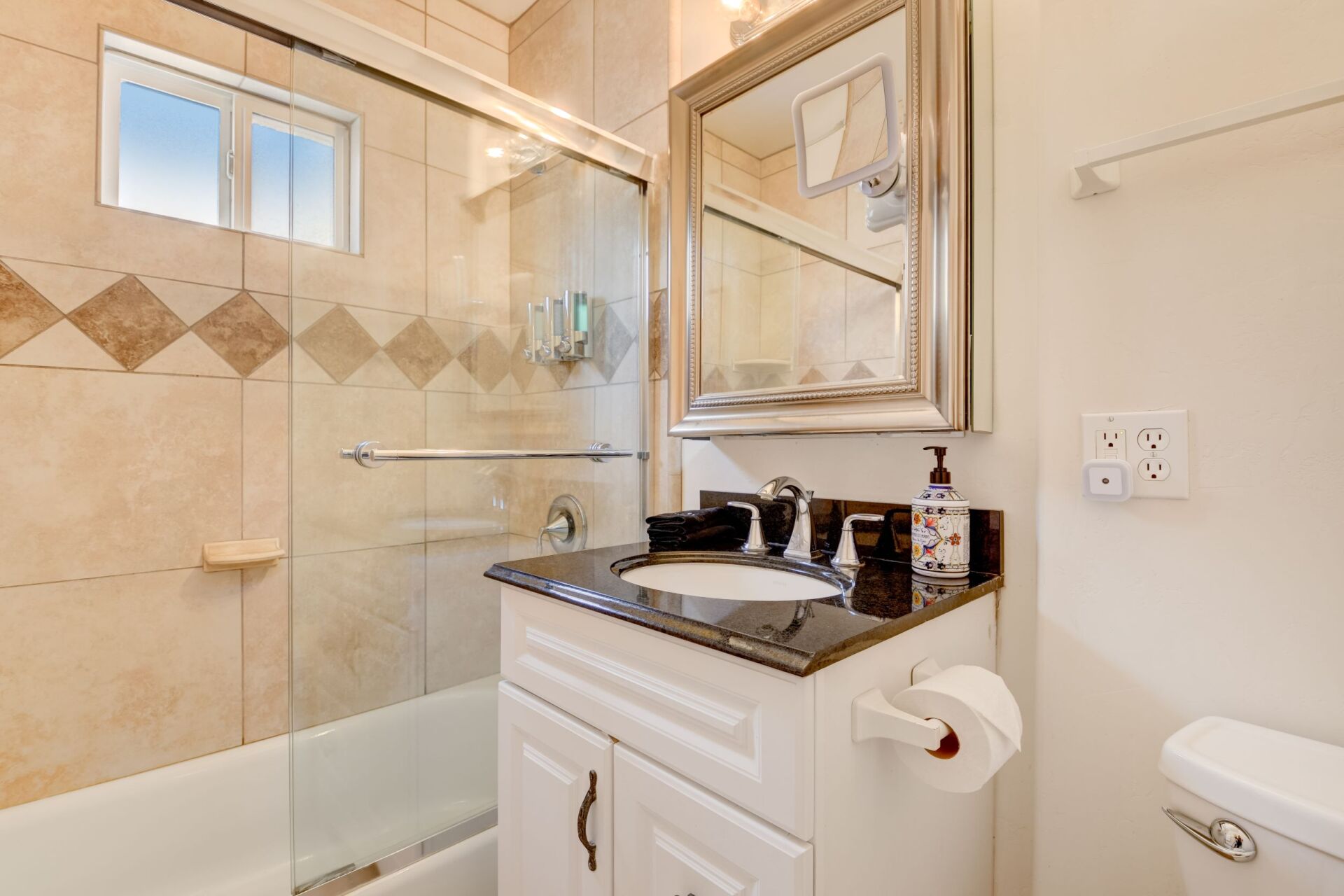 A bathroom with a sink , toilet and shower.