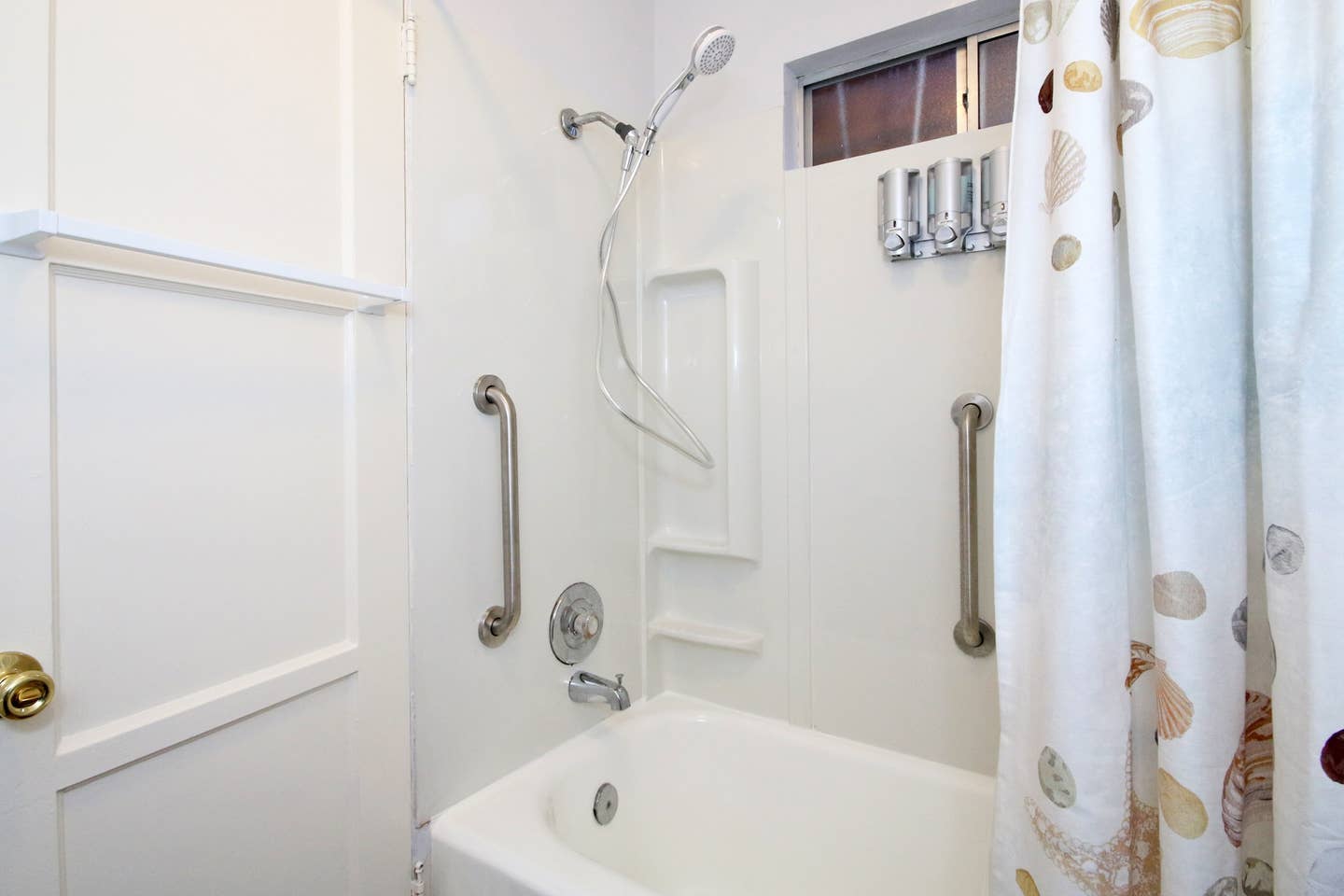 a bathroom with a bathtub , shower , and handrails .