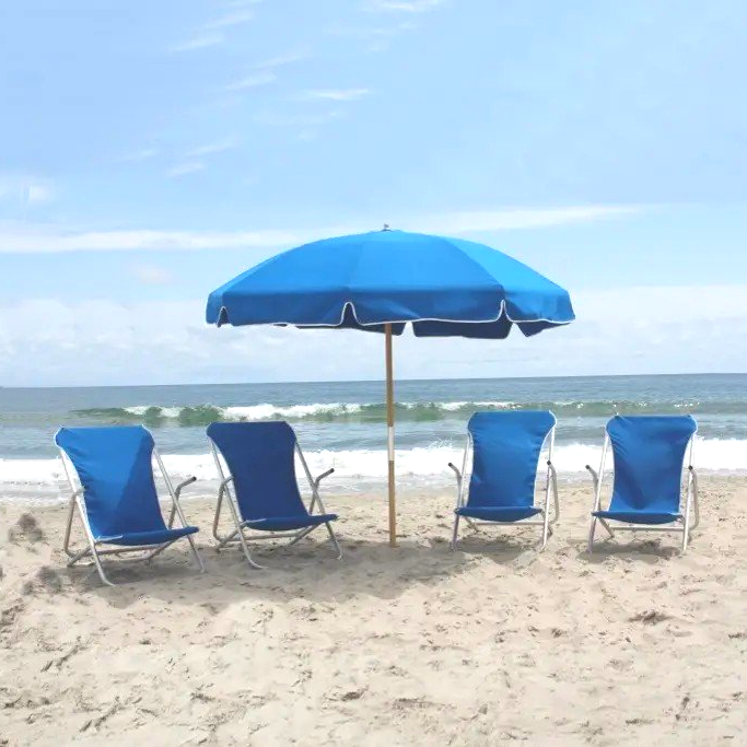 four blue chairs under a blue umbrella on the beach