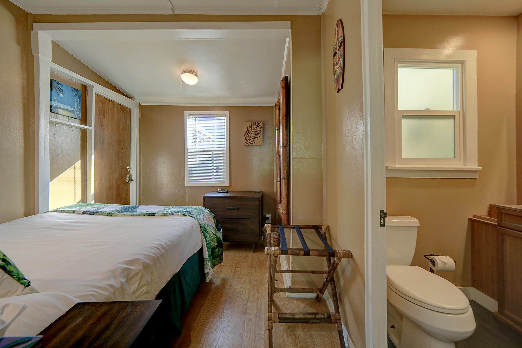 a bedroom with two beds , a toilet , and a window .