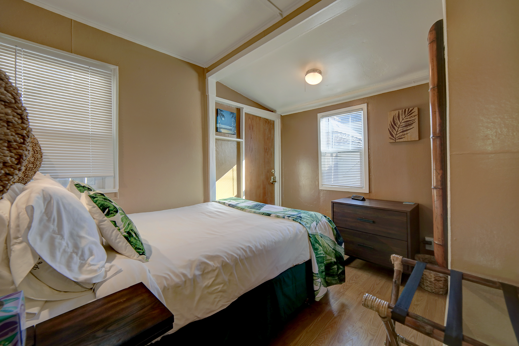 a bedroom with a bed , dresser , chair and window .