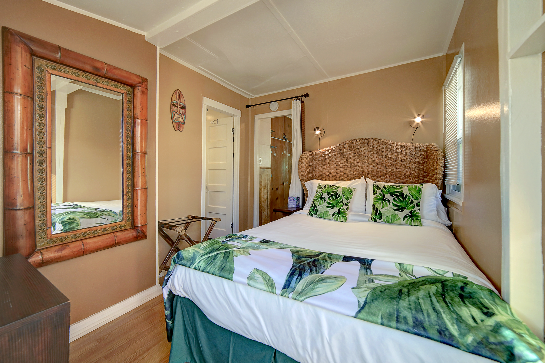 a bedroom with a bed , mirror and dresser .