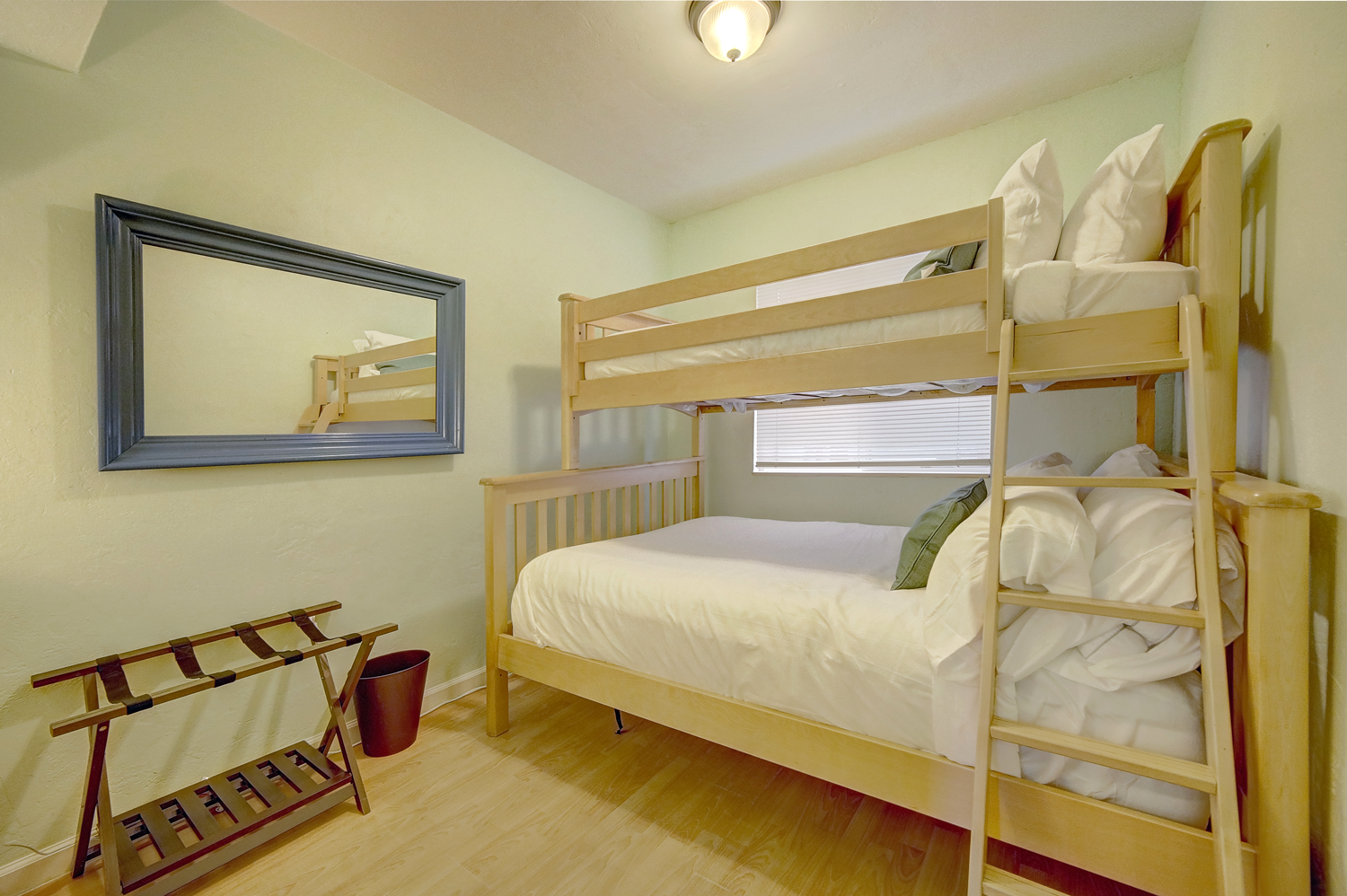 a bedroom with two bunk beds and a mirror .