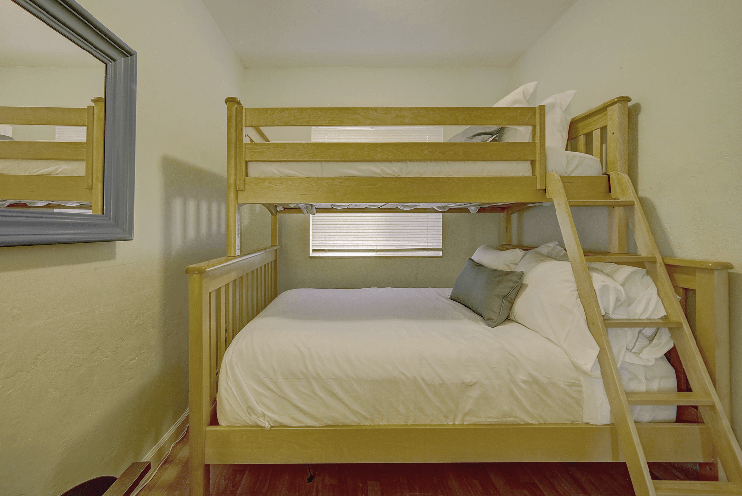 a bedroom with a bunk bed and a mirror .