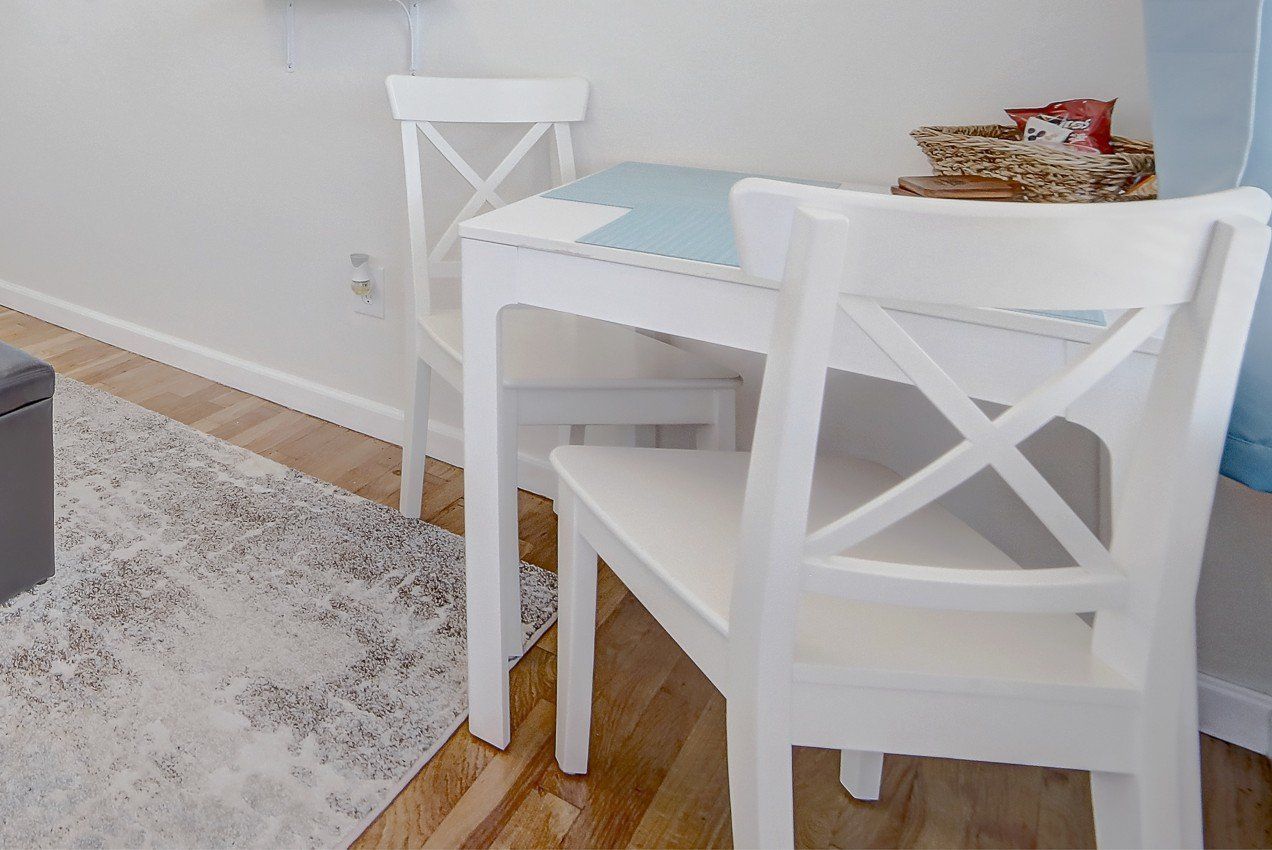 A white table and chairs in a living room