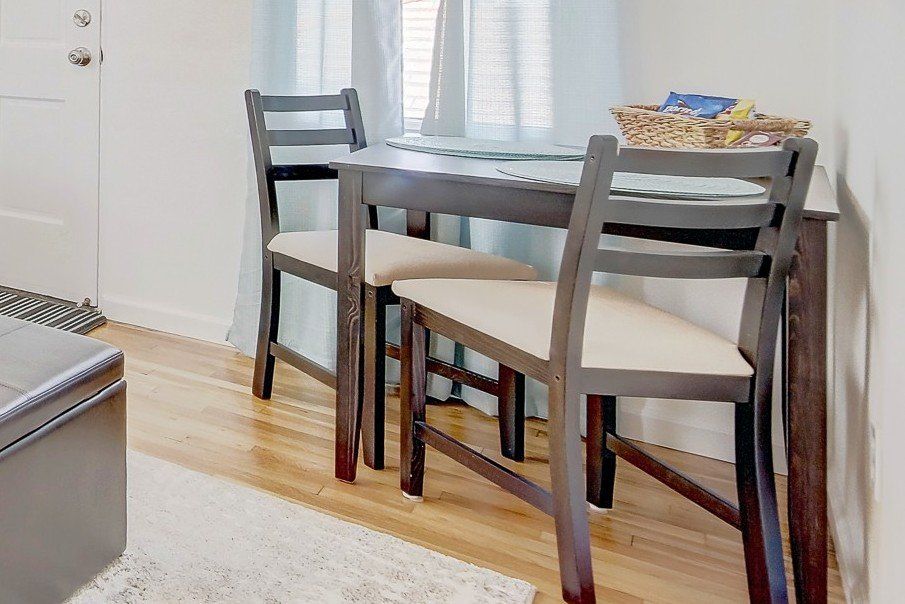 A small dining table with two chairs in a living room.