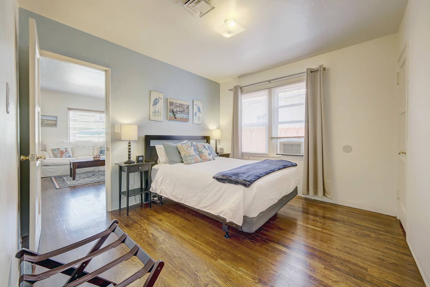 A bedroom with a large bed and hardwood floors.