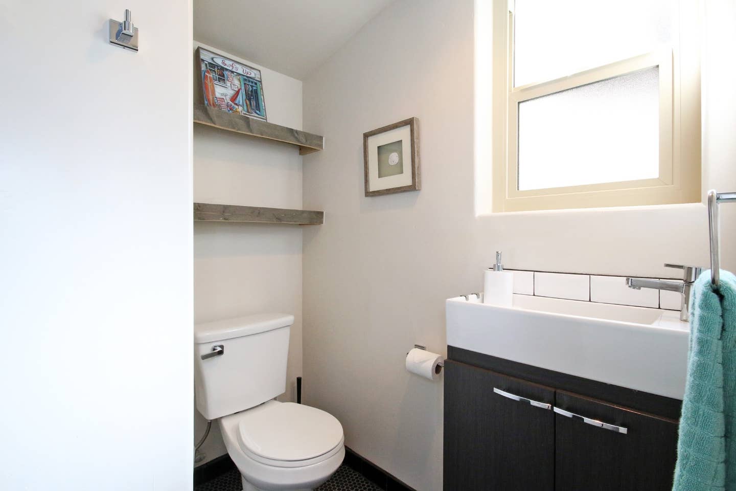 A bathroom with a toilet , sink and window