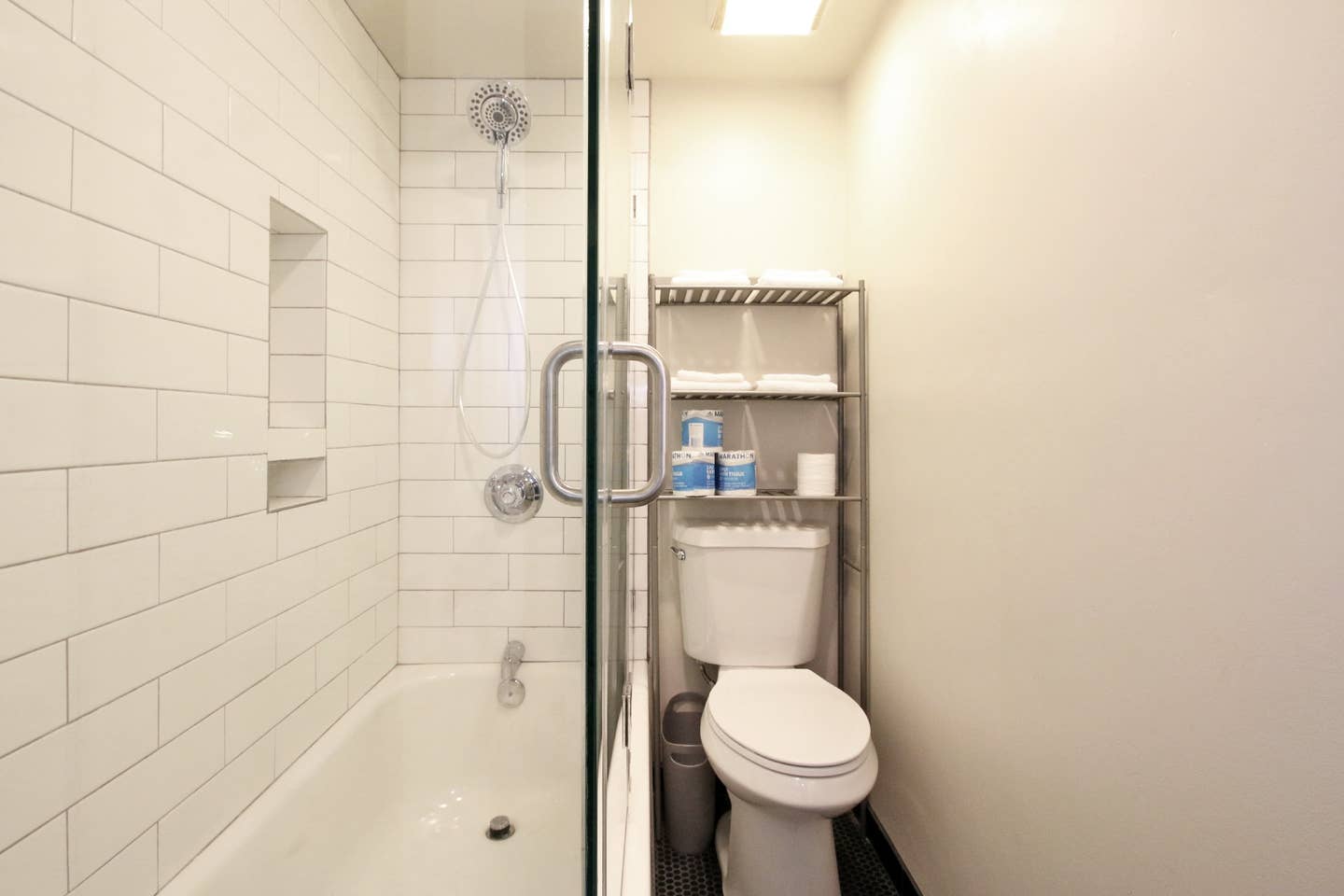 A bathroom with a toilet , bathtub and shower.