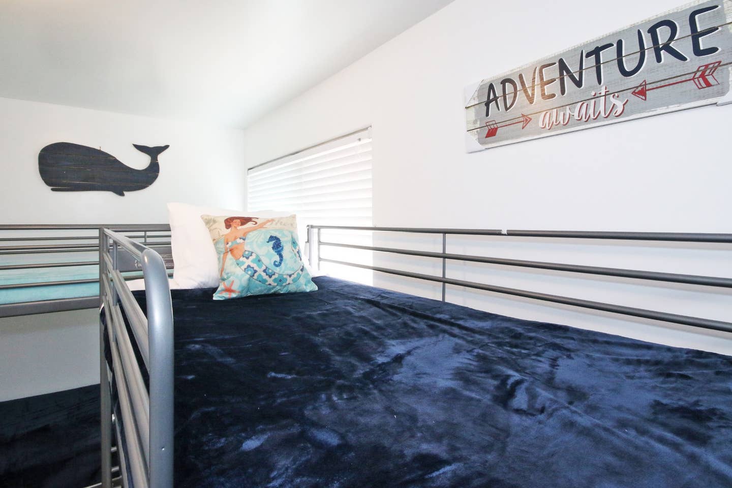 A bunk bed with a sign on the wall that says adventure.