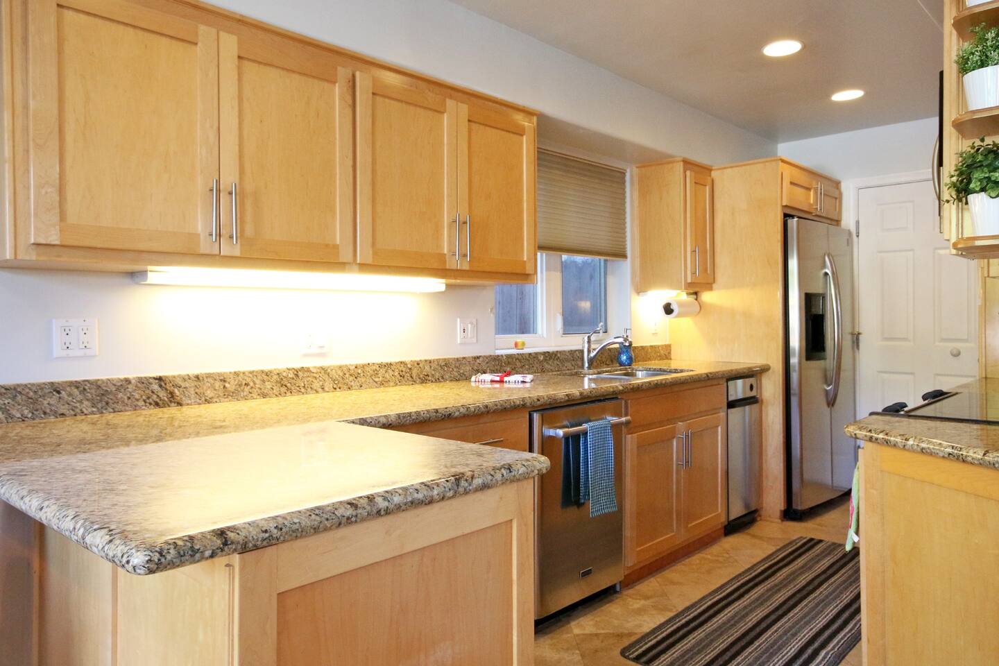 a kitchen with wooden cabinets and granite counter tops