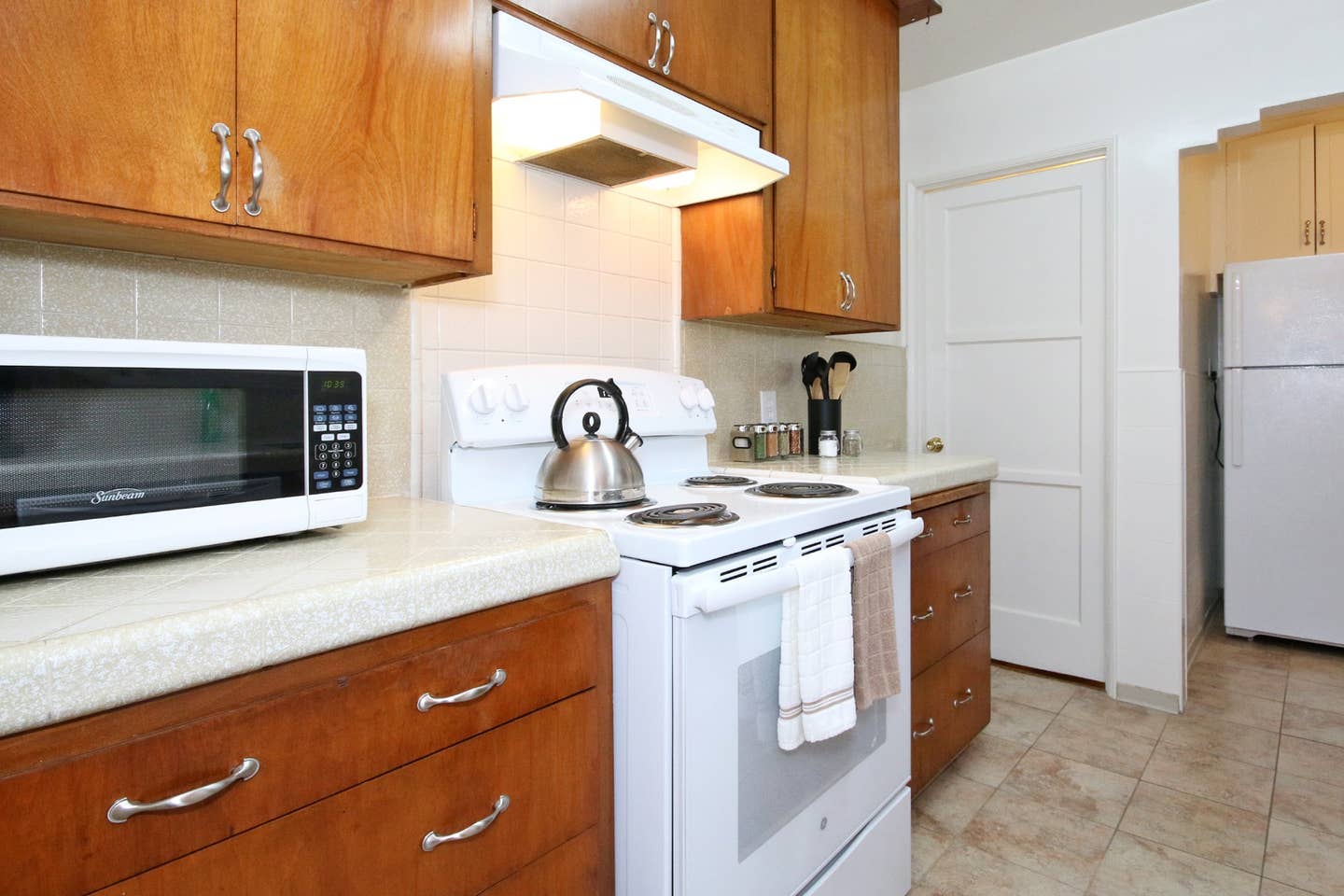 A kitchen with a stove , microwave , and refrigerator