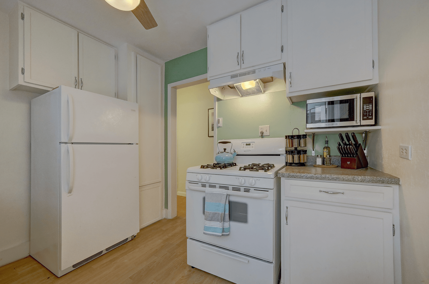 A kitchen with a stove , refrigerator , and microwave.