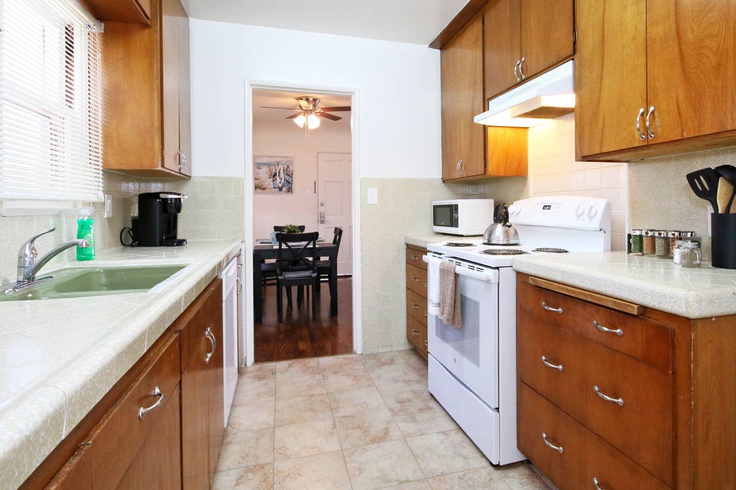 A kitchen with wooden cabinets and a white stove