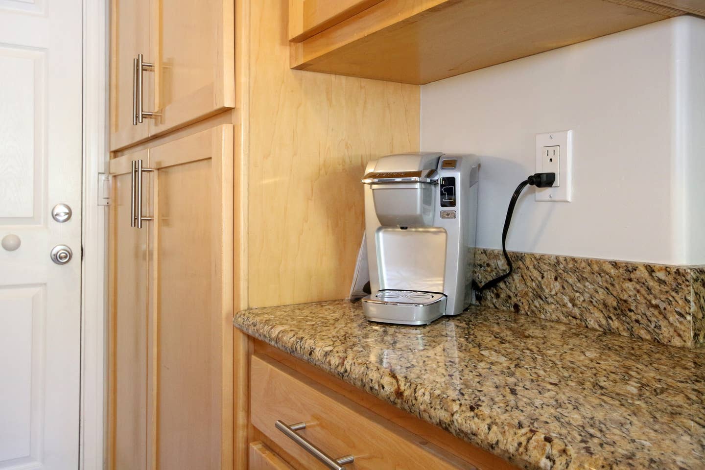 a coffee maker is sitting on a granite counter in a kitchen .